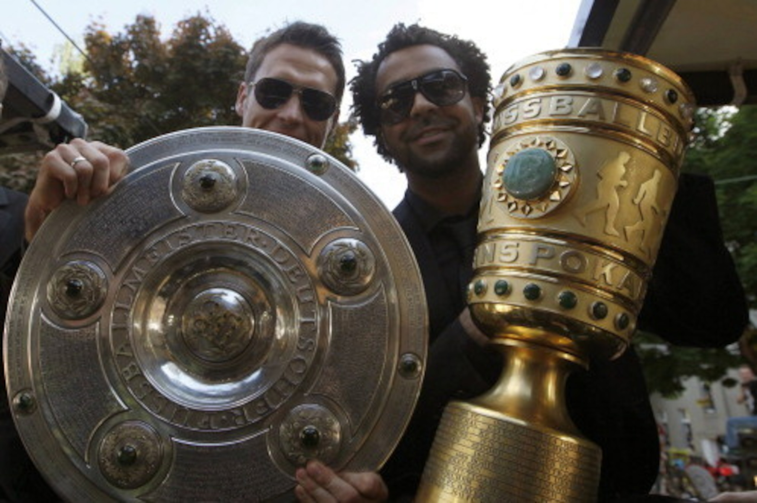 (From L to R) Dortmund's Croatian midfielder Ivan Perisic,Dortmund's midfielder Sebastian Kehl and Dortmund's defender Patrick Owomoyela hold the German soccer championship trophy and the German DFB Cup during a parade after Borussia Dortmund won the Germ