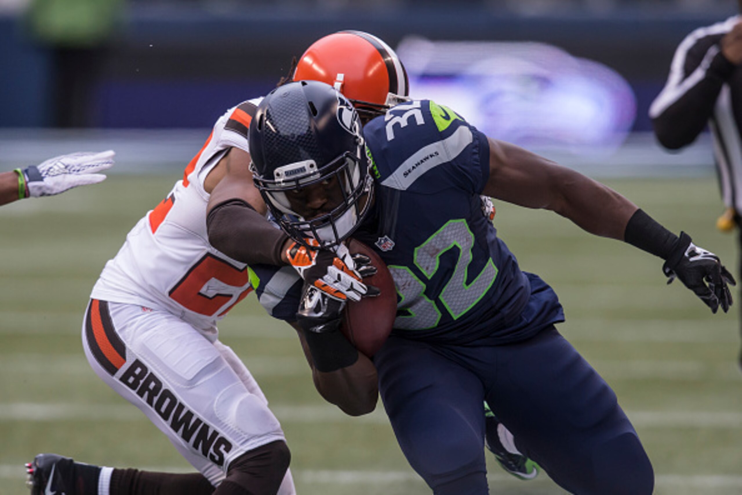 SEATTLE, WA - DECEMBER 20: Running back Christine Michael #32 of the Seattle Seahawks runs with the ball as defensive back Tramon Williams #22 of the Cleveland Browns tries to make the tackle during the first half of a football game at CenturyLink Field o