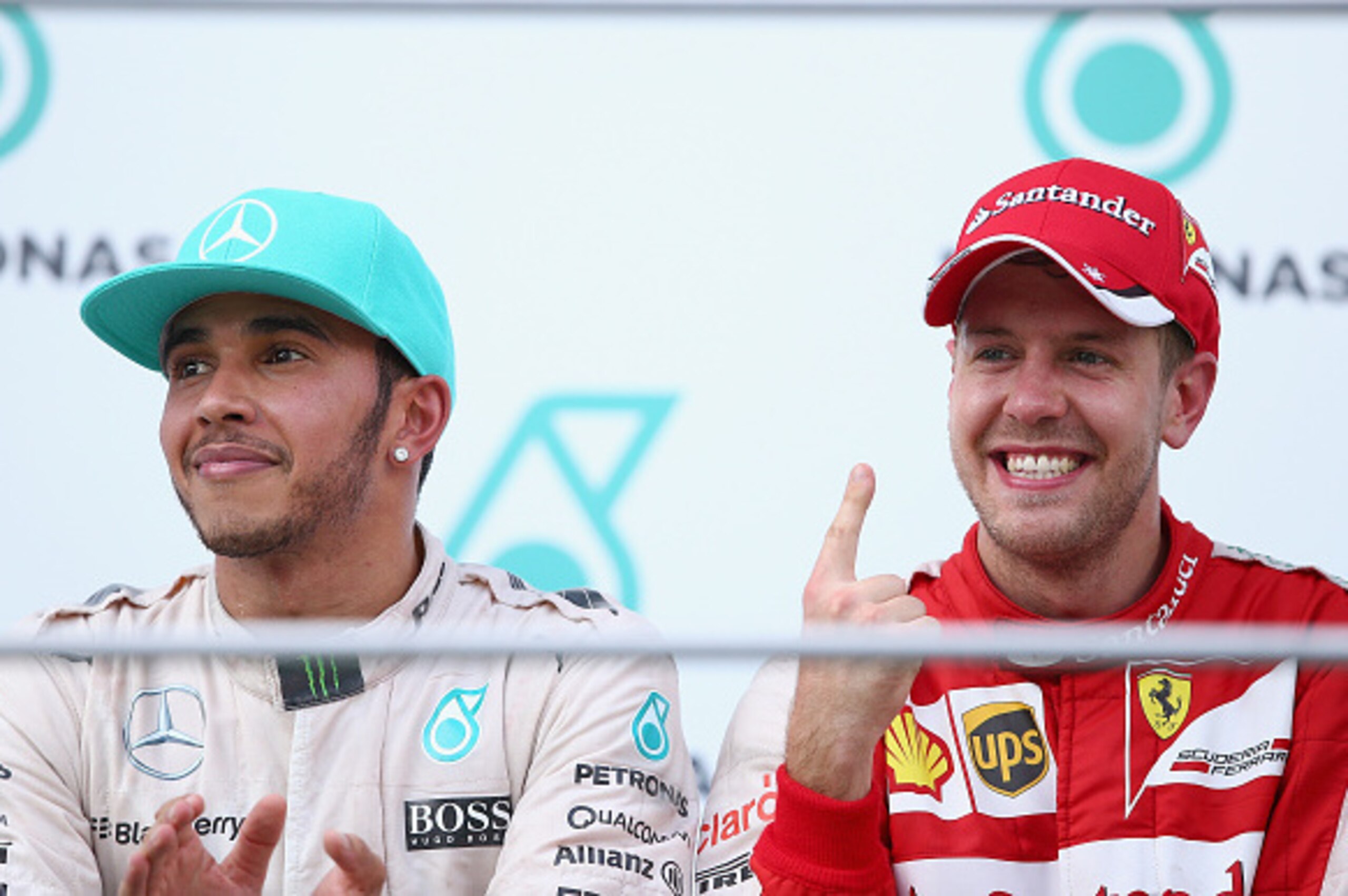 KUALA LUMPUR, MALAYSIA - MARCH 29:  Sebastian Vettel of Germany and Ferrari celebrates on the podium next to Lewis Hamilton of Great Britain and Mercedes GP after winning the Malaysia Formula One Grand Prix at Sepang Circuit on March 29, 2015 in Kuala Lum