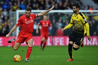 Liverpool's English midfielder Jordan Henderson (L) clears the ball closed down by Watford's Uruguayan defender Miguel Britos (R) during the English Premier League football match between Watford and Liverpool at Vicarage Road Stadium in Watford, north of 