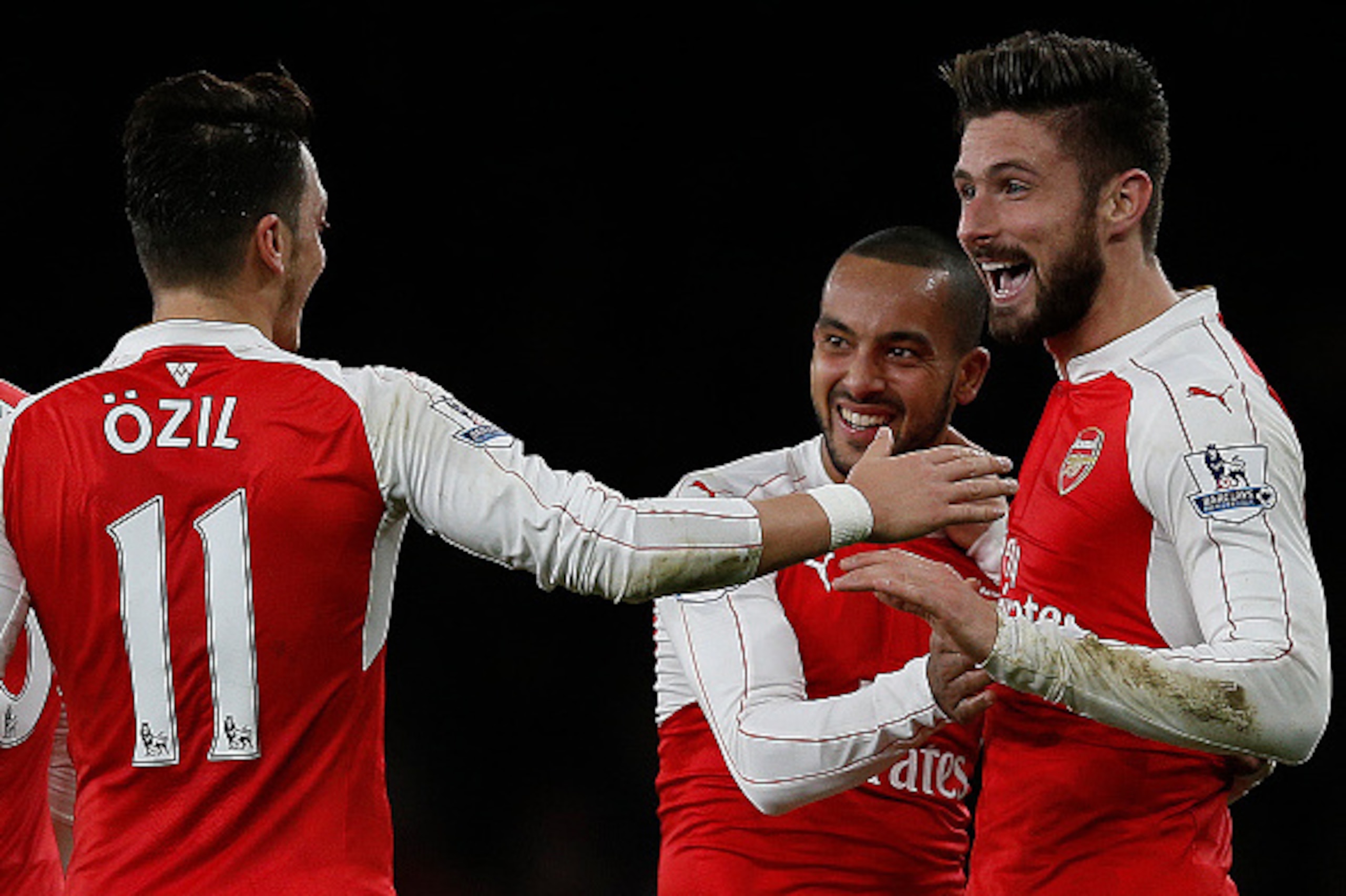 Arsenal's French striker Olivier Giroud (R) celebrates scoring his team's second goal with Arsenal's English midfielder Theo Walcott (R) and Arsenal's German midfielder Mesut Ozil during the English Premier League football match between Arsenal and Manche