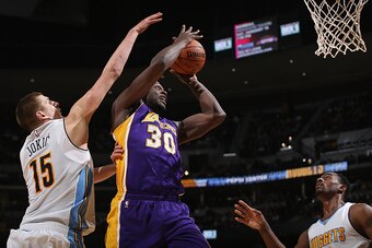 DENVER, CO - DECEMBER 22:  Julius Randle #30 of the Los Angeles Lakers takes a shot against Nikola Jokic #15 and Darrell Arthur #00 of the Denver Nuggets at Pepsi Center on December 22, 2015 in Denver, Colorado. NOTE TO USER: User expressly acknowledges a