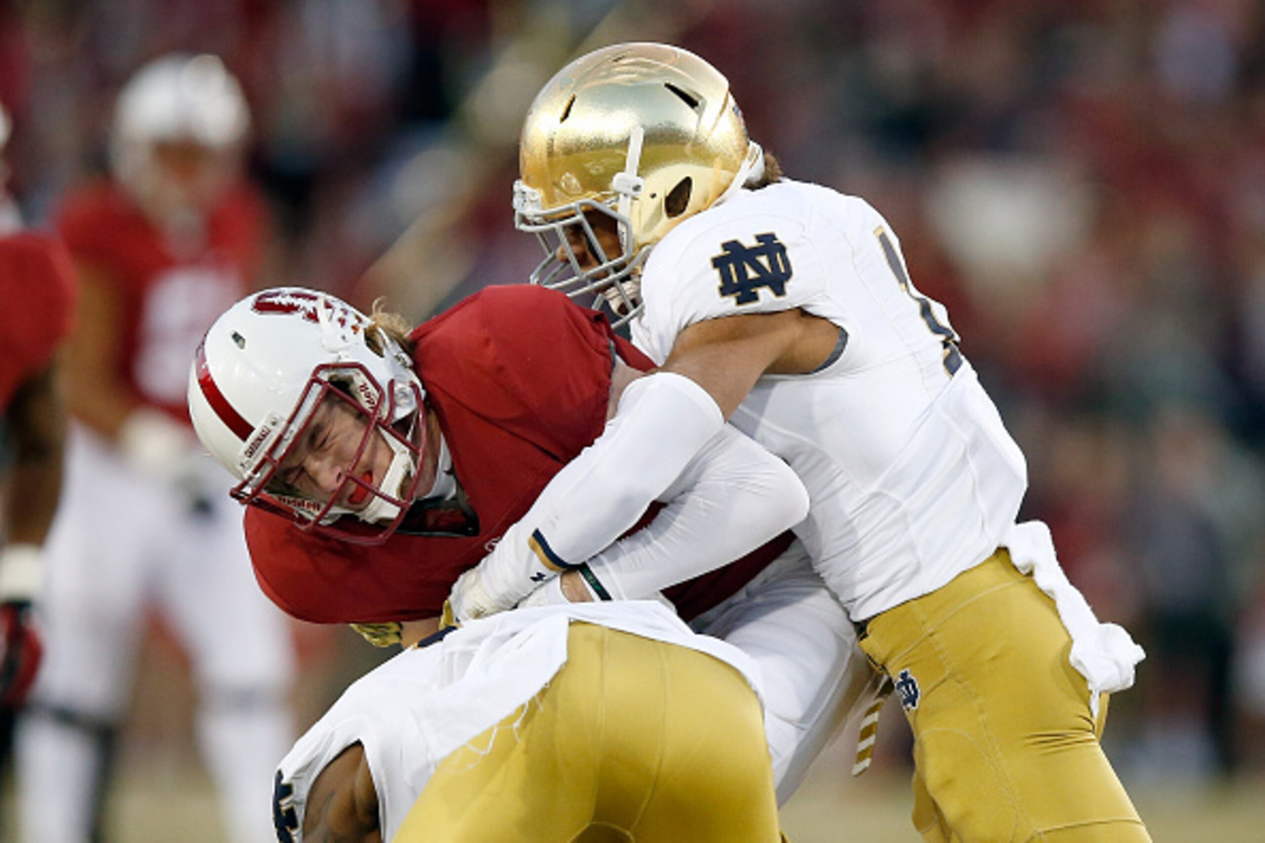 PALO ALTO, CA - NOVEMBER 28:  Trenton Irwin #2 of the Stanford Cardinal is tackled by Max Redfield #10 and Devin Butler #12 of the Notre Dame Fighting Irish at Stanford Stadium on November 28, 2015 in Palo Alto, California.  (Photo by Ezra Shaw/Getty Imag