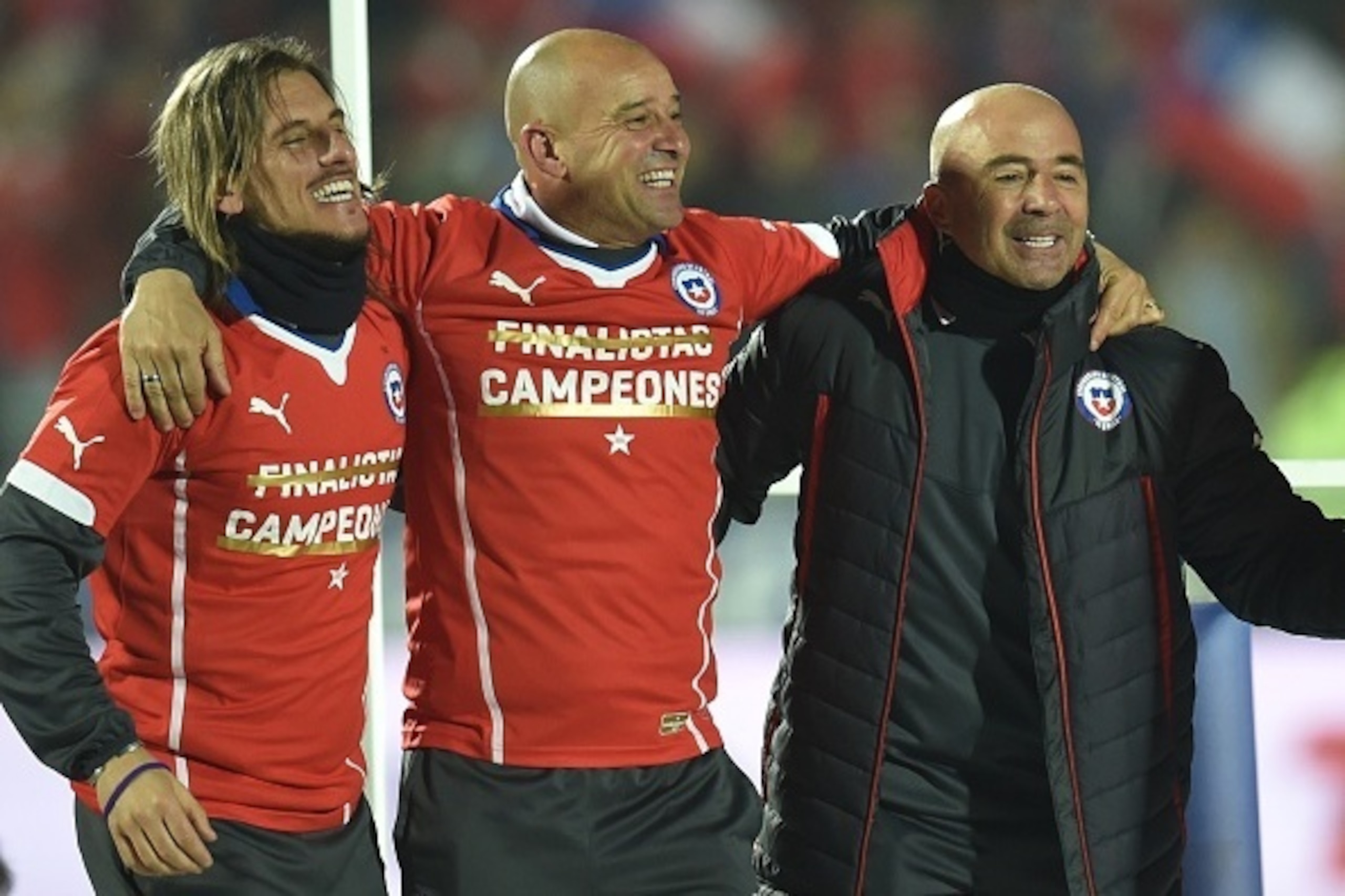 Chile's coach Jorge Sampaoli (R) celebrates with teammates after winning the 2015 Copa America football championship final against Argentina, in Santiago, Chile, on July 4, 2015.   AFP PHOTO / RODRIGO ARANGUA        (Photo credit should read RODRIGO ARANG
