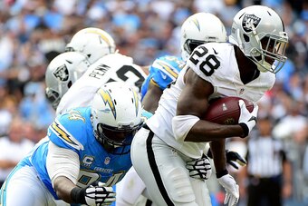 SAN DIEGO, CA - OCTOBER 25:  Latavius Murray #28 of the Oakland Raiders carries the ball as he is chased by Corey Liuget #94 of the San Diego Chargers during the first quarter at Qualcomm Stadium on October 25, 2015 in San Diego, California.  (Photo by Ha