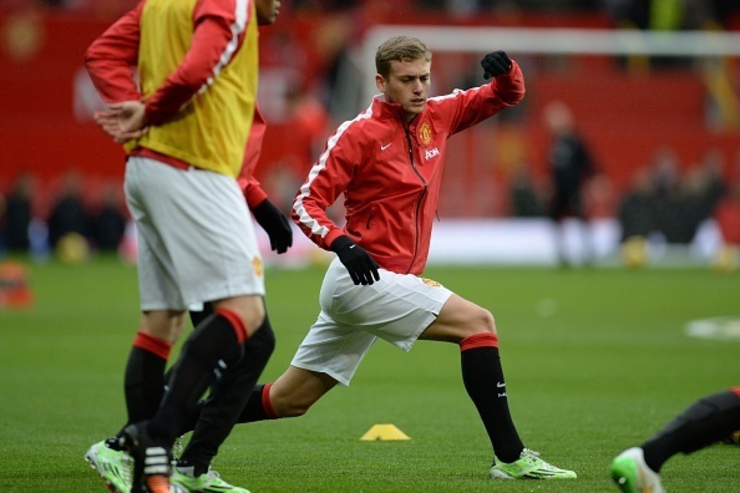 Manchester United's English striker James Wilson does stretching exercises ahead of the English Premier League football match between Manchester United and Liverpool at Old Trafford in Manchester, north west England, on December 14, 2014. AFP PHOTO / OLI 