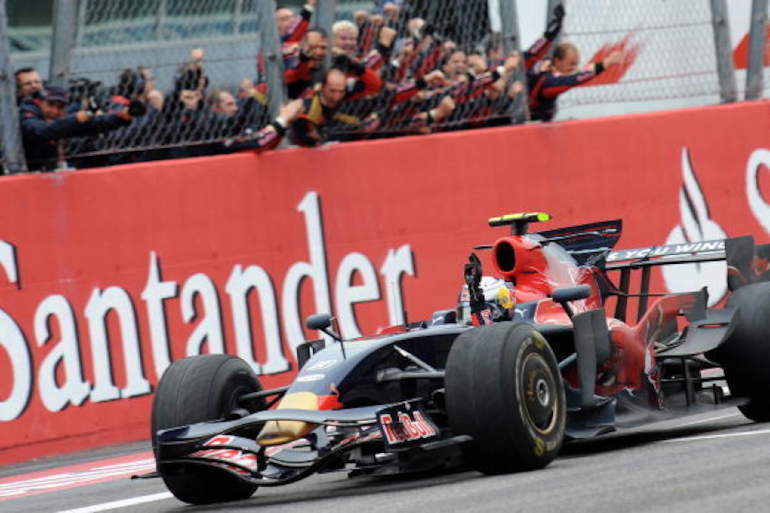 Toro Rosso's German driver Sebastien Vettel, congratulated by his team members, celebrates as he crosses the finish line of the Monza racetrack on September 14, 2008 near Milan, after the Italian Formula One Grand Prix. Toro Rosso's German driver Sebastie