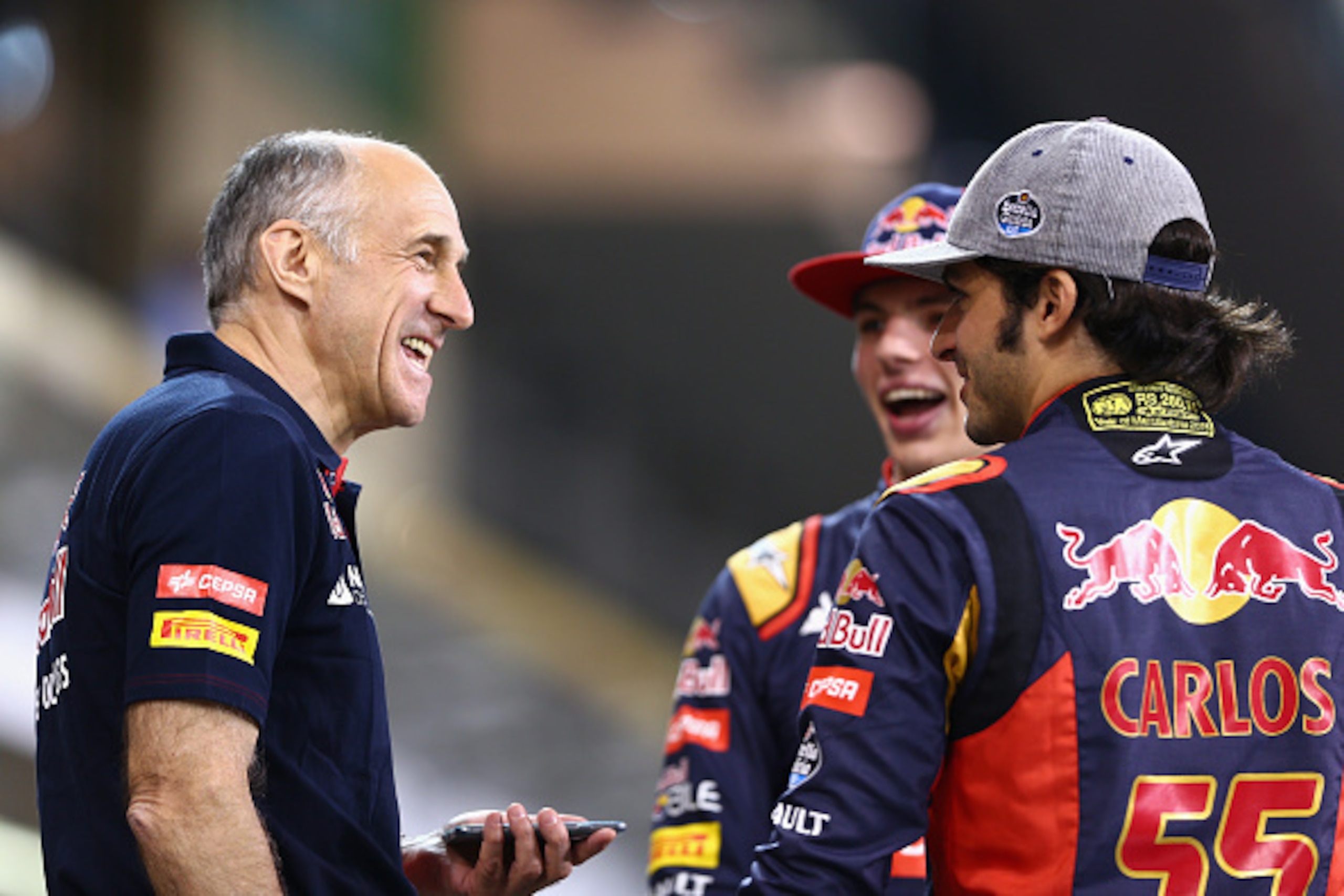 ABU DHABI, UNITED ARAB EMIRATES - NOVEMBER 26:  Max Verstappen of Netherlands and Scuderia Toro Rosso speaks with Carlos Sainz of Spain and Scuderia Toro Rosso and Scuderia Toro Rosso Team Principal Franz Tost as they wait in the pit lane for a team photo