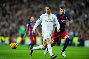 MADRID, SPAIN - NOVEMBER 21:  Cristiano Ronaldo of Real Madrid duels for the ball with Gerard Pique of Barcelona during the La Liga match between Real Madrid CF and FC Barcelona at Estadio Santiago Bernabeu on November 21, 2015 in Madrid, Spain.  (Photo b