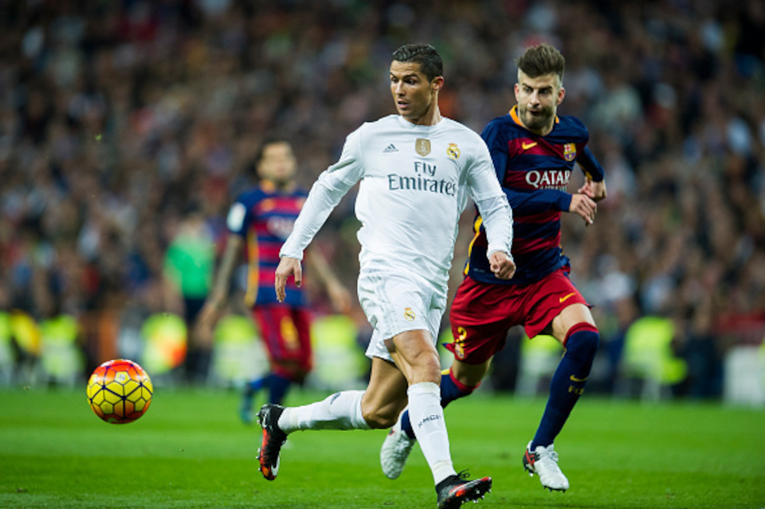 MADRID, SPAIN - NOVEMBER 21:  Cristiano Ronaldo of Real Madrid duels for the ball with Gerard Pique of Barcelona during the La Liga match between Real Madrid CF and FC Barcelona at Estadio Santiago Bernabeu on November 21, 2015 in Madrid, Spain.  (Photo b
