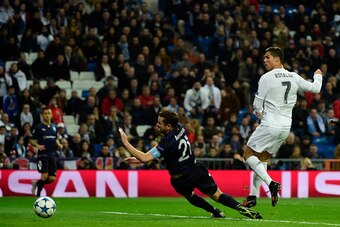 Real Madrid's Portuguese forward Cristiano Ronaldo (R) kicks the ball to score his fourth goal during the UEFA Champions League Group A football match Real Madrid CF vs Malmo FF at the Santiago Bernabeu stadium in Madrid on December 8, 2015.   AFP PHOTO/ 