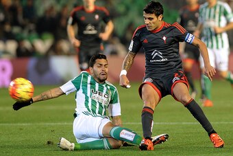Celta Vigo's Argentinian midfielder Augusto Fernandez (R) vies with Betis' midfielder Petros (L) during the Spanish league football match Real Betis vs RC Celta de Vigo at the Benito Villamarin stadium in Sevilla on December 5, 2015.   AFP PHOTO / CRISTIN
