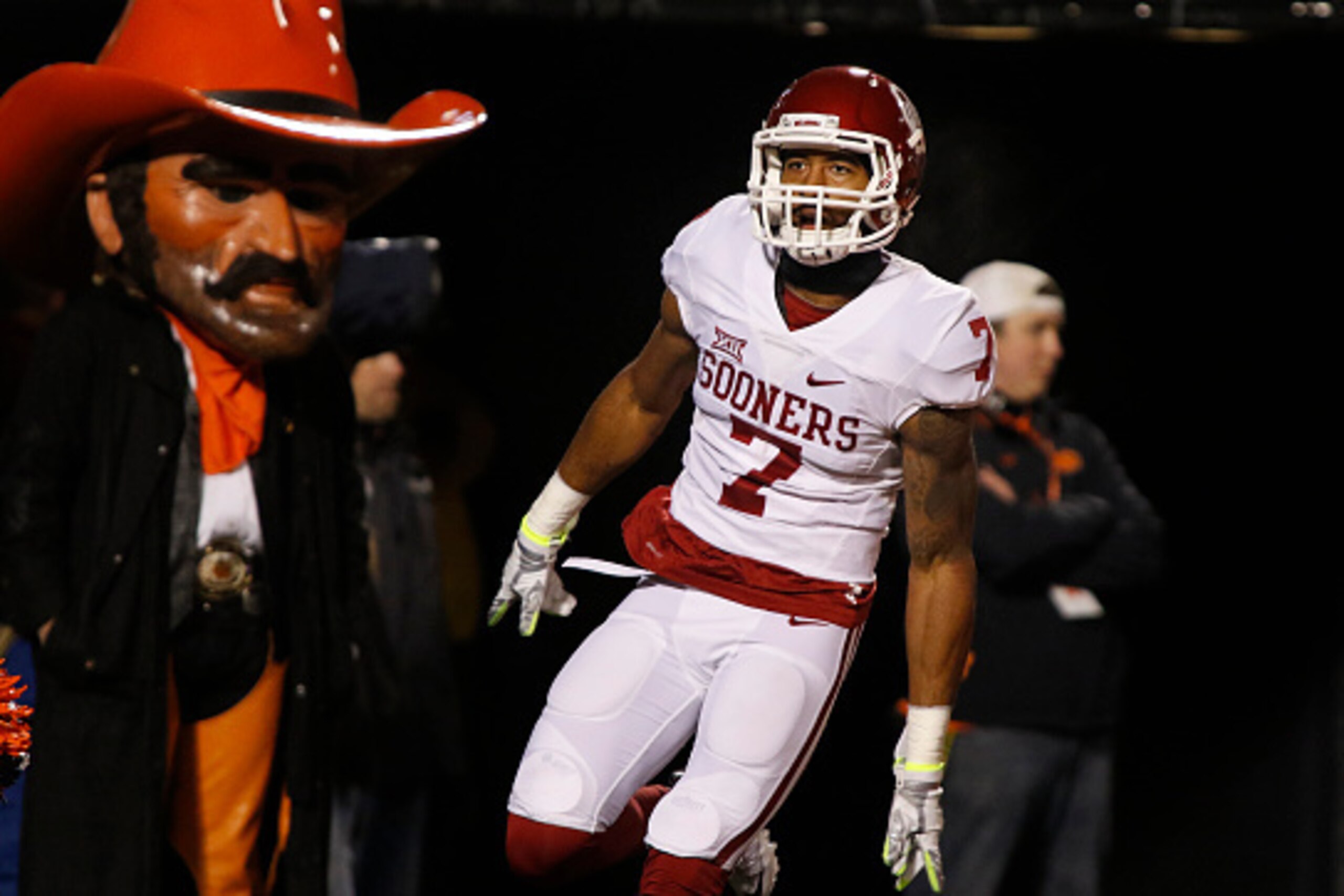 STILLWATER, OK - NOVEMBER 28 : Cornerback Jordan Thomas #7 of the Oklahoma Sooners runs past Pistol Pete after an interception and touchdown against the Oklahoma State Cowboys November 28, 2015 at Boone Pickens Stadium in Stillwater, Oklahoma. Oklahoma de