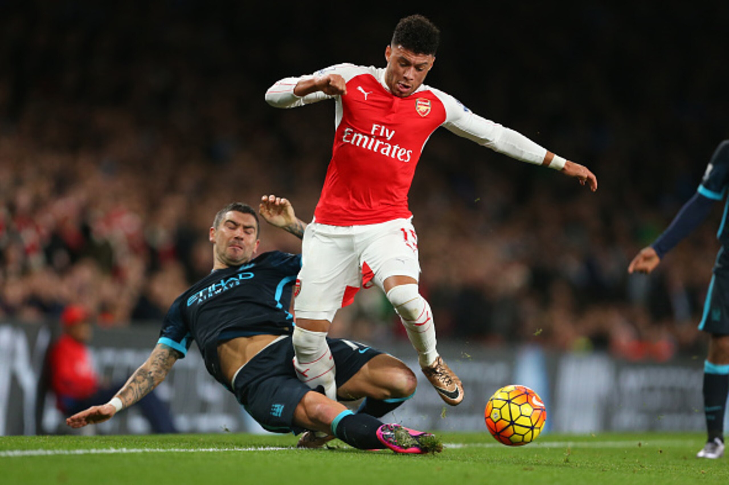 LONDON, ENGLAND - DECEMBER 21:  Aleksandar Kolarov of Manchester City tackles Alex Oxlade-Chamberlain of Arsenal during the Barclays Premier League match between Arsenal and Manchester City at the Emirates Stadium on December 21, 2015 in London, England. 