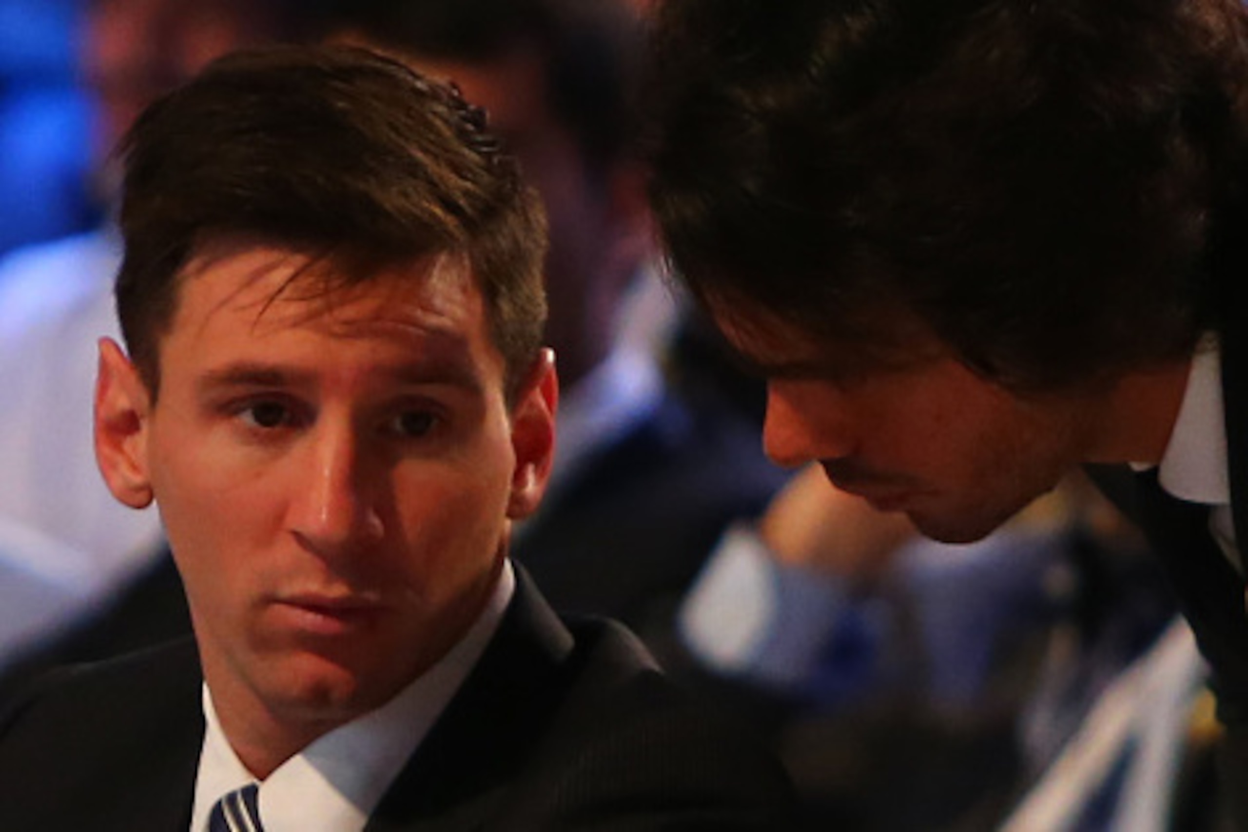 Barcelona football striker Lionel Messi (L) speaks with an event organiser as he attends the opening session of the 10th edition of Dubai International Sports Conference in Dubai on December 27, 2015. AFP PHOTO / MARWAN NAAMANI / AFP / MARWAN NAAMANI     