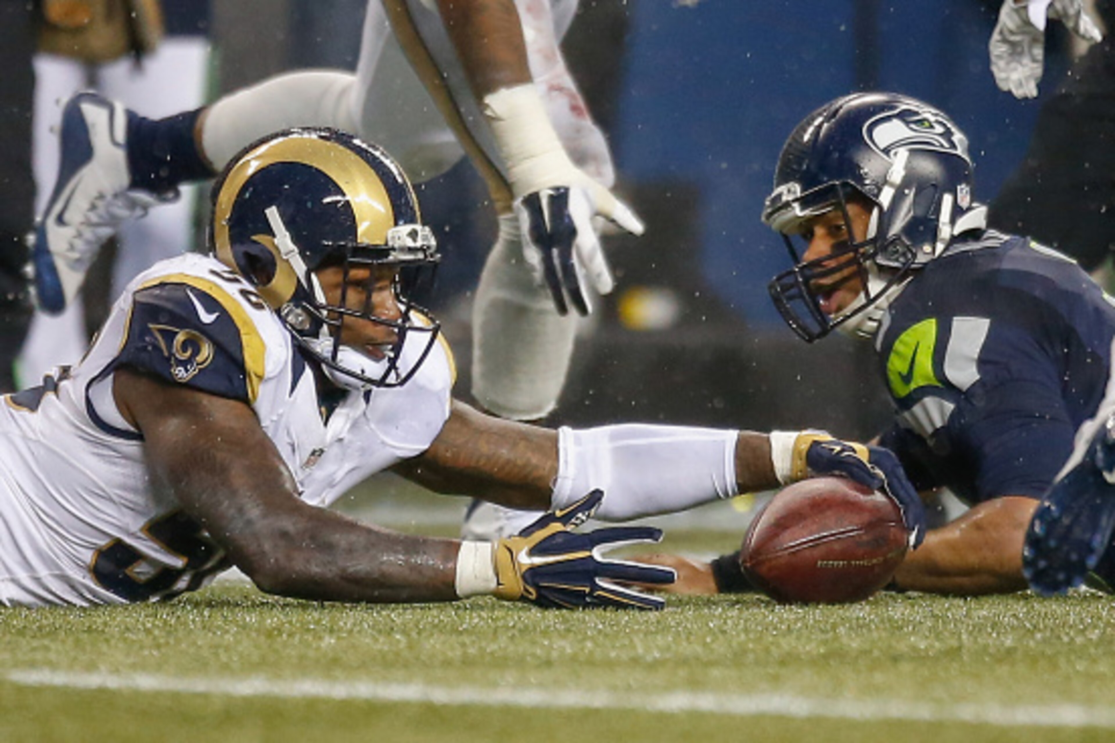SEATTLE, WA - DECEMBER 27:  Quarterback Russell Wilson #3 of the Seattle Seahawks fumbles as linebacker Akeem Ayers #56 of the St. Louis Rams recovers with under two minutes to play at CenturyLink Field on December 27, 2015 in Seattle, Washington.  The Ra