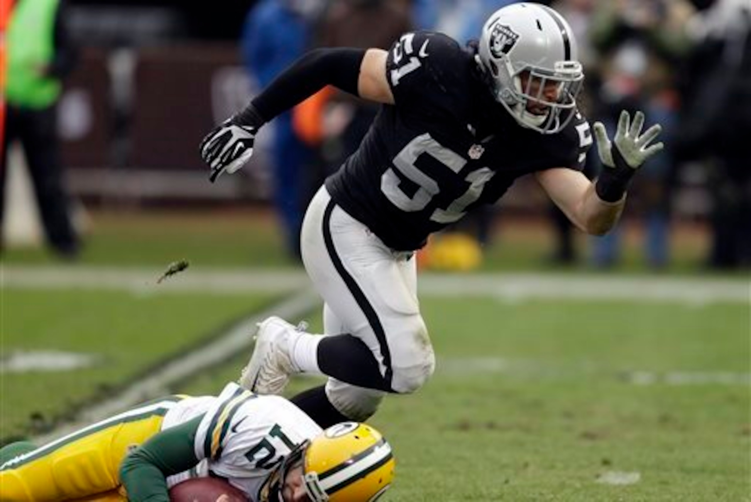 Raiders linebacker Ben Heeney sacks Green Bay Packers quarterback Aaron Rodgers and gets up to celebrate.