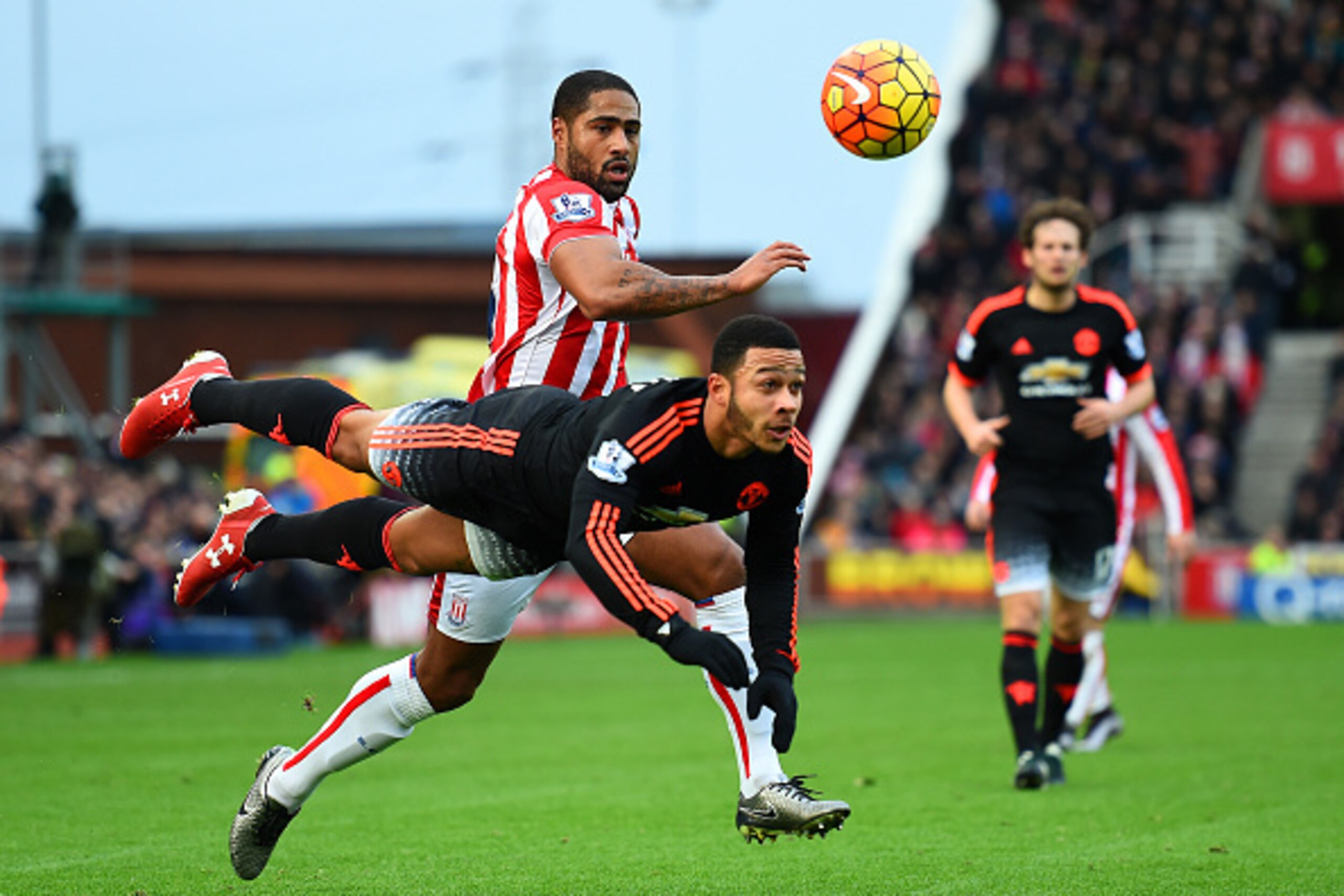STOKE ON TRENT, ENGLAND - DECEMBER 26:  Memphis Depay of Manchester United heads the ball under pressure from Glen Johnson of Stoke City during the Barclays Premier League match between Stoke City and Manchester United at Britannia Stadium on December 26,