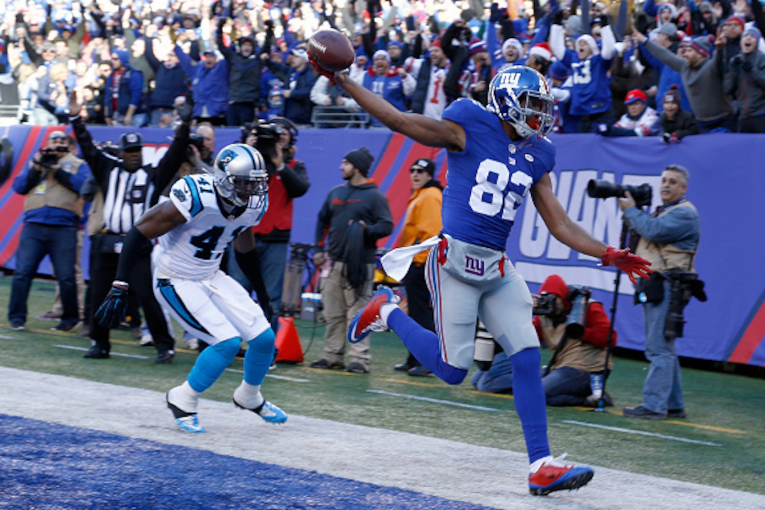 EAST RUTHERFORD, NJ - DECEMBER 20:  Rueben Randle #82 of the New York Giants scores a 27 yard touchdown in the first quarter against Roman Harper #41 of the Carolina Panthers during their game at MetLife Stadium on December 20, 2015 in East Rutherford, Ne
