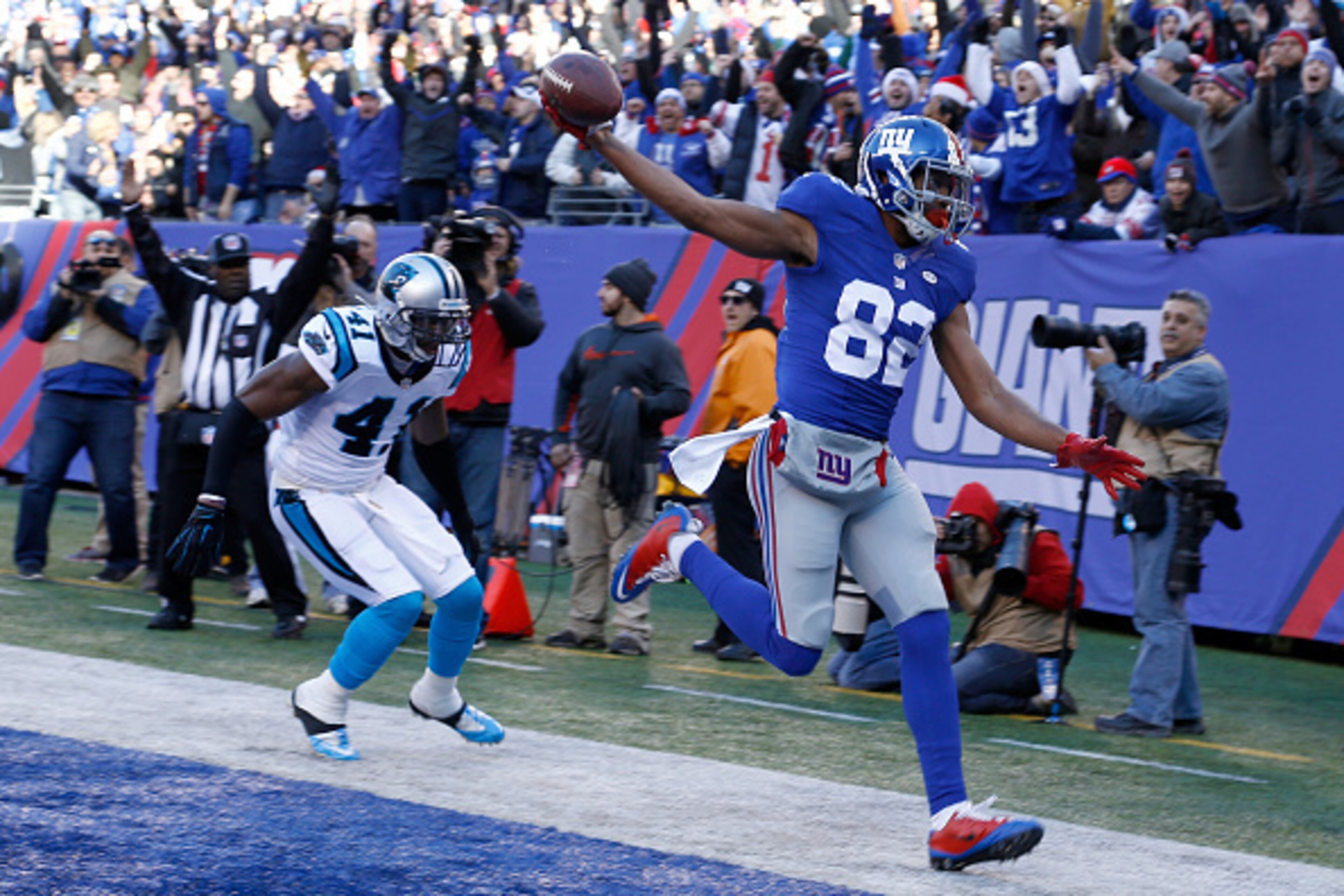 EAST RUTHERFORD, NJ - DECEMBER 20:  Rueben Randle #82 of the New York Giants scores a 27 yard touchdown in the first quarter against Roman Harper #41 of the Carolina Panthers during their game at MetLife Stadium on December 20, 2015 in East Rutherford, Ne