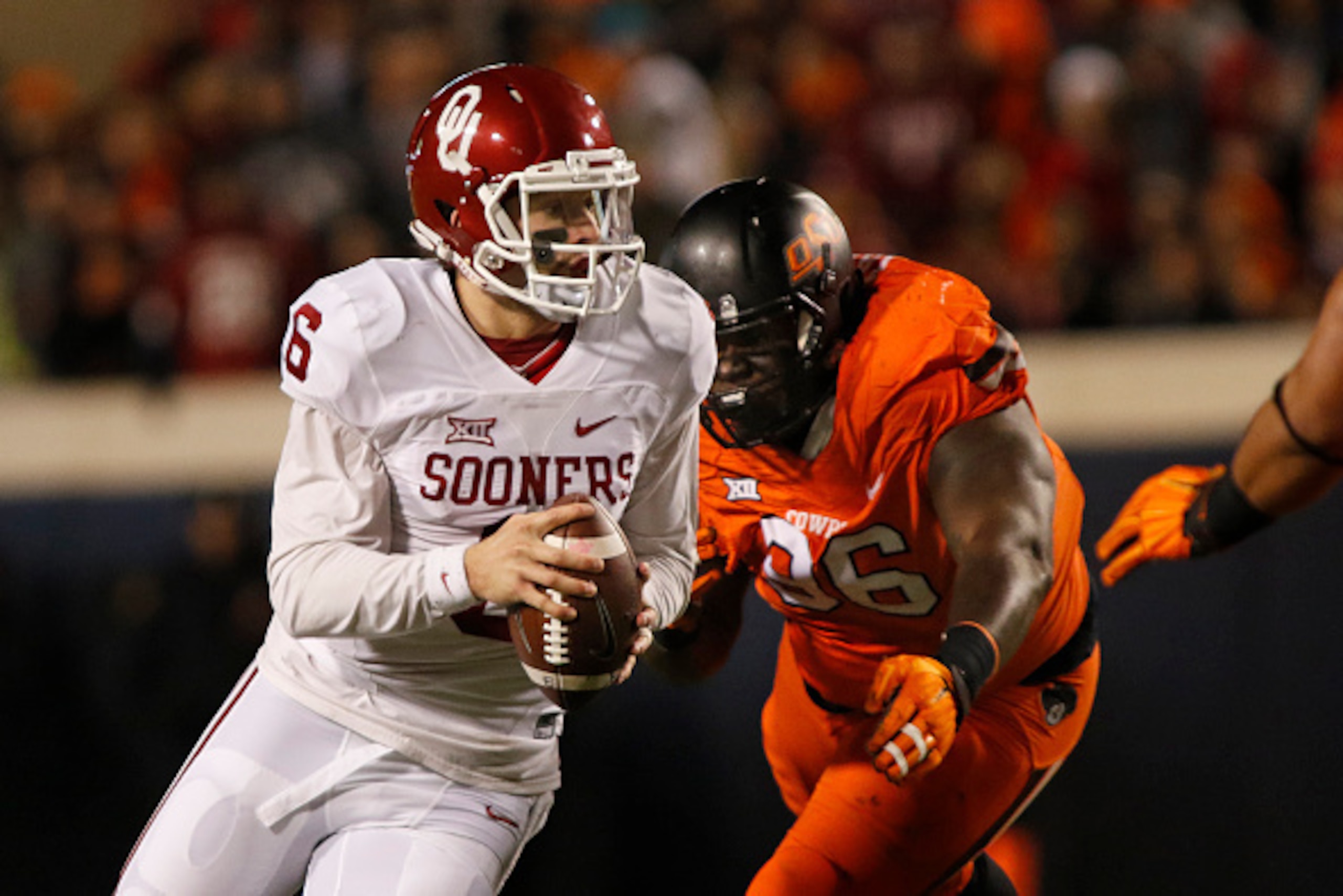 STILLWATER, OK - NOVEMBER 28 : Quarterback Baker Mayfield #6 of the Oklahoma Sooners scrambles under pressure from defensive tackle Vincent Taylor #96 of the Oklahoma State Cowboys November 28, 2015 at Boone Pickens Stadium in Stillwater, Oklahoma. Oklaho