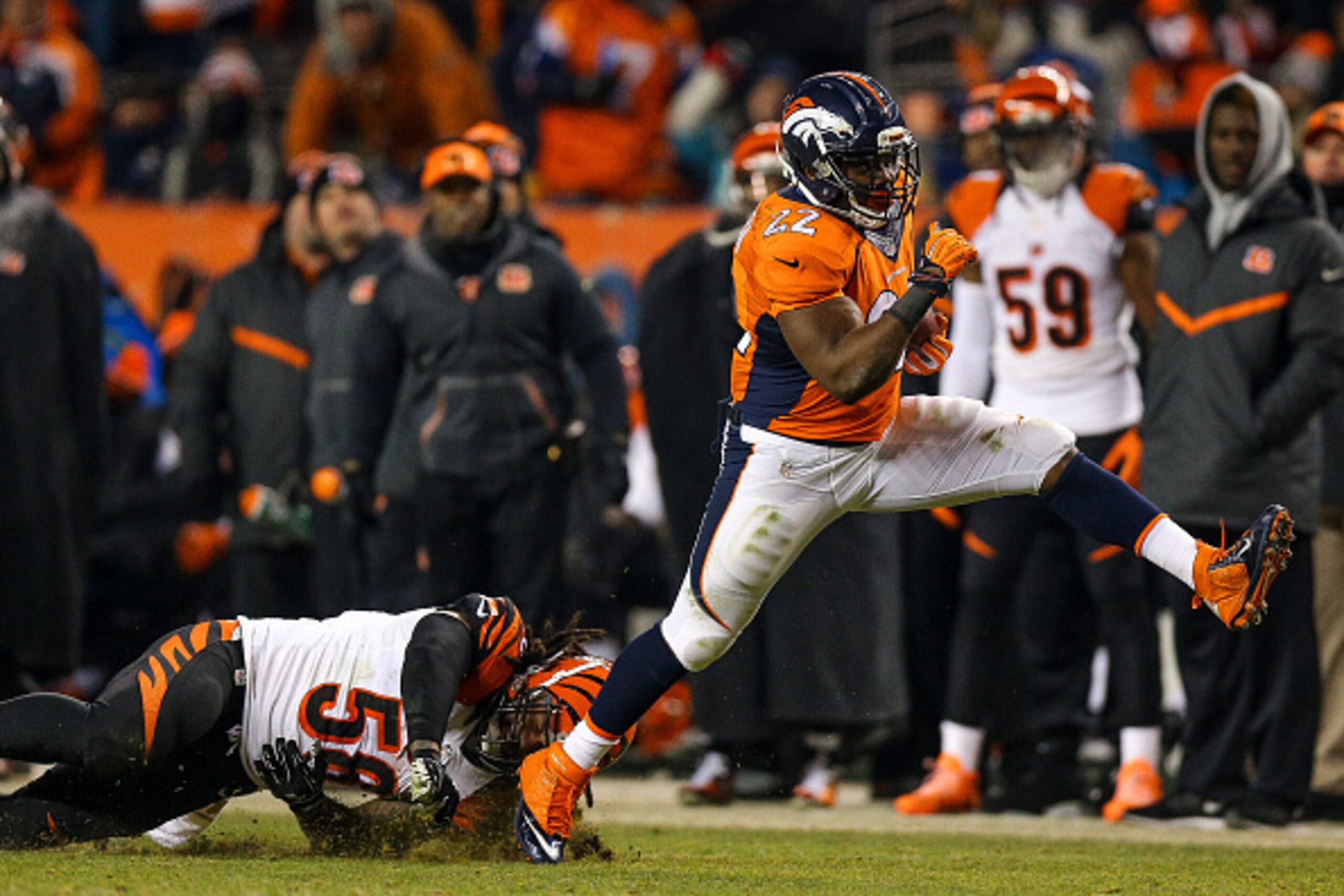 DENVER, CO - DECEMBER 28:  Running back C.J. Anderson #22 of the Denver Broncos breaks away from a tackle attempt by middle linebacker Rey Maualuga #58 of the Cincinnati Bengals as he rushes for a 39 yard fourth quarter go-ahead touchdown during a game at