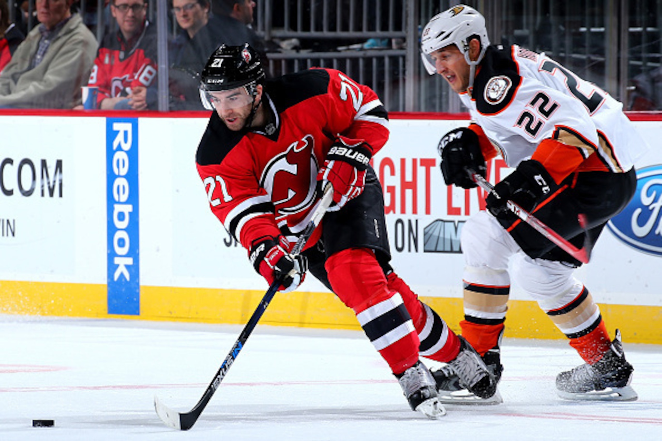 NEWARK, NJ - DECEMBER 19:  Kyle Palmieri #21 of the New Jersey Devils takes the puck as Shawn Horcoff #22 of the Anaheim Ducks defends on December 19, 2015 at Prudential Center in Newark, New Jersey.The Anaheim Ducks defeated the New Jersey Devils 2-1.  (