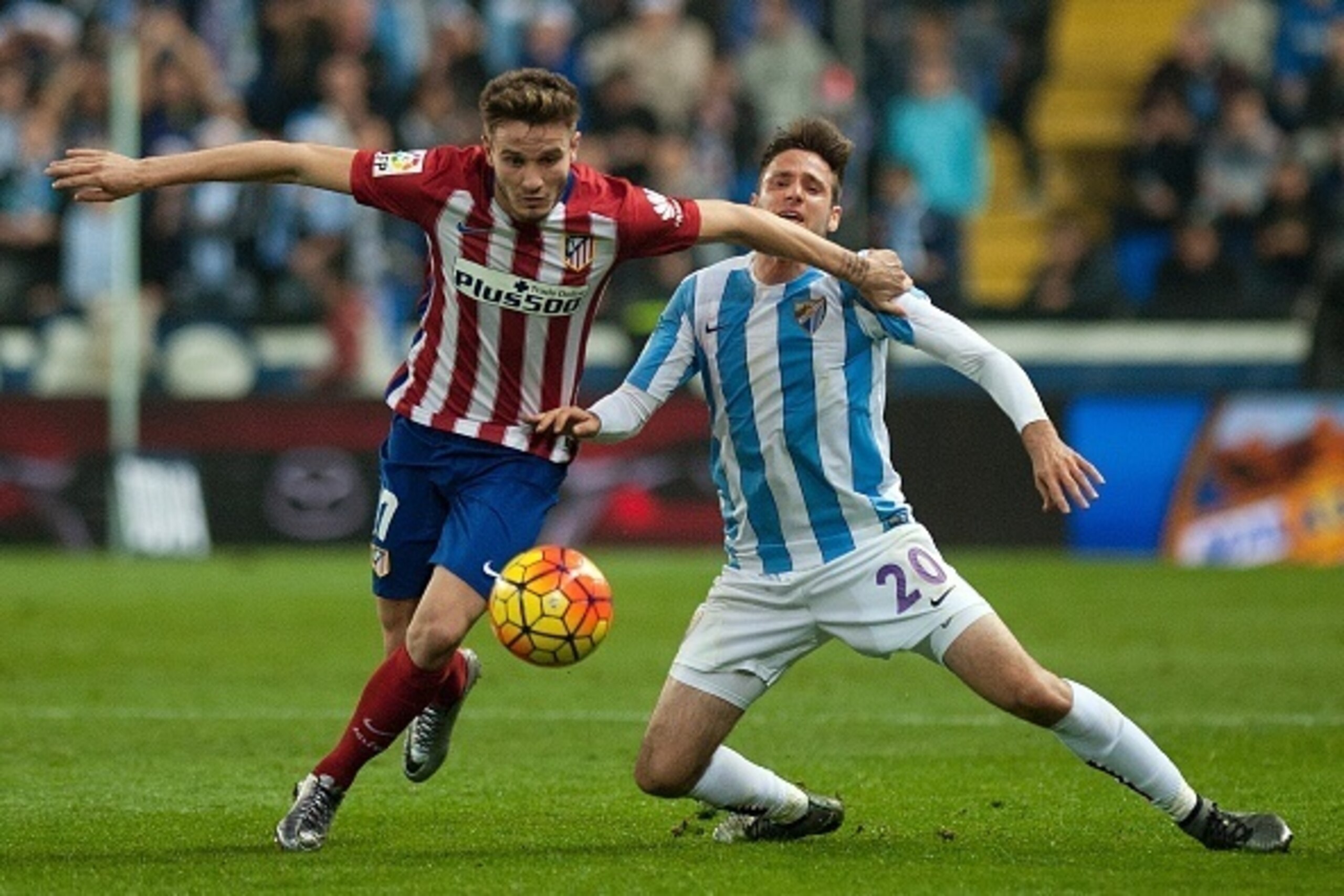 Atletico Madrid's midfielder Saul Niguez (L) vies with Malaga's Croatian forward Duje Cop during the Spanish league football match Malaga CF vs Club Atletico de Madrid at La Rosaleda stadium in Malaga on December 20, 2015. AFP PHOTO / JORGE GUERRERO / AFP