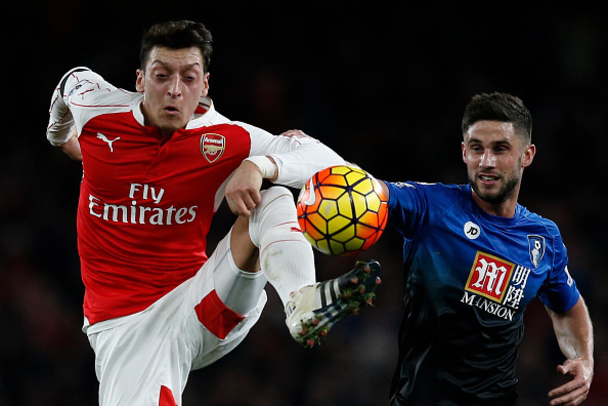Arsenal's German midfielder Mesut Ozil controls the ball in front of Bournemouth's South African-born English midfielder Andrew Surman (R) during the English Premier League football match between Arsenal and Bournemouth at the Emirates Stadium in London o
