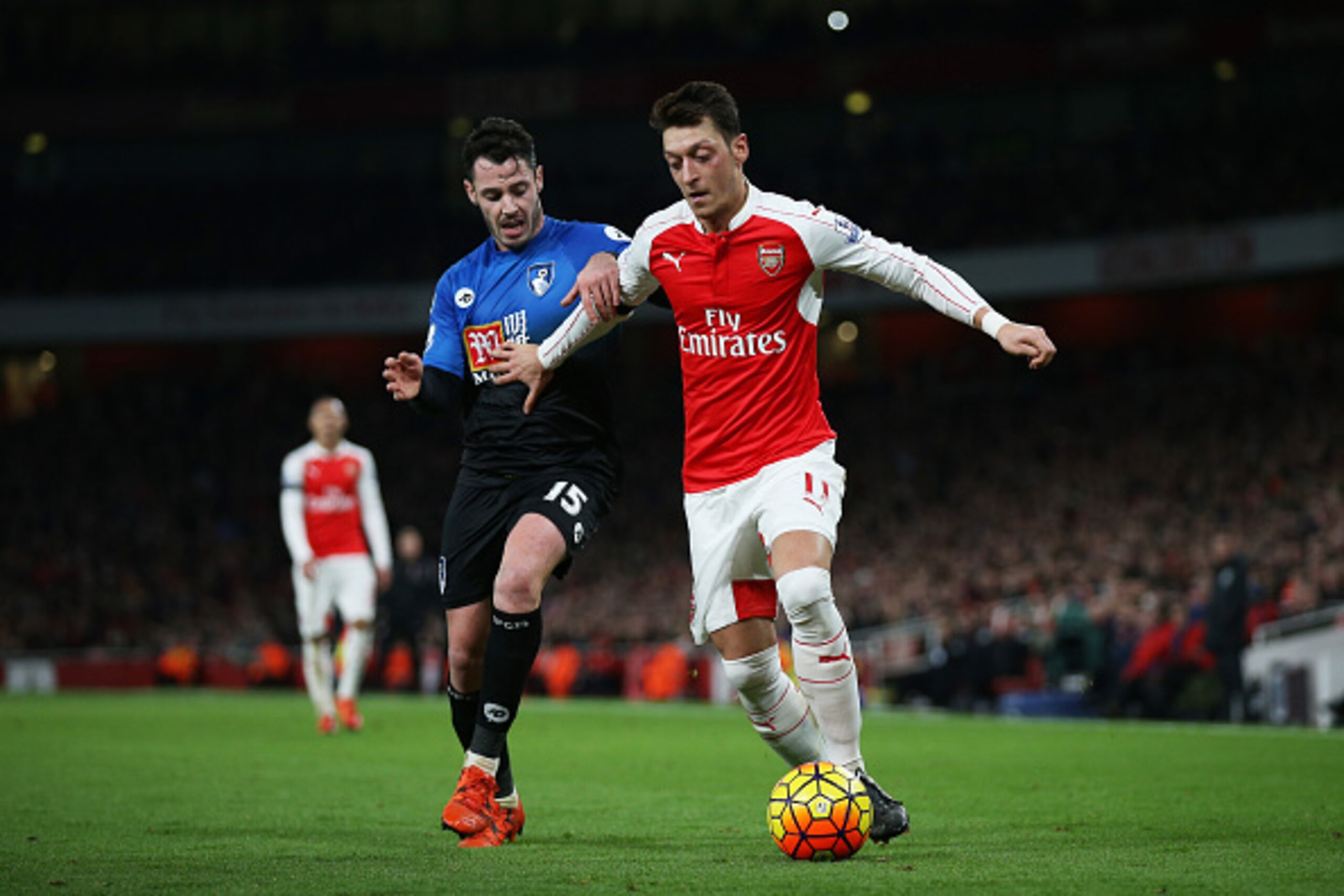 LONDON, ENGLAND - DECEMBER 28:  Mesut Ozil of Arsenal and Adam Smith of Bournemouth compete for the ball during the Barclays Premier League match between Arsenal and A.F.C. Bournemouth at Emirates Stadium on December 28, 2015 in London, England.  (Photo b