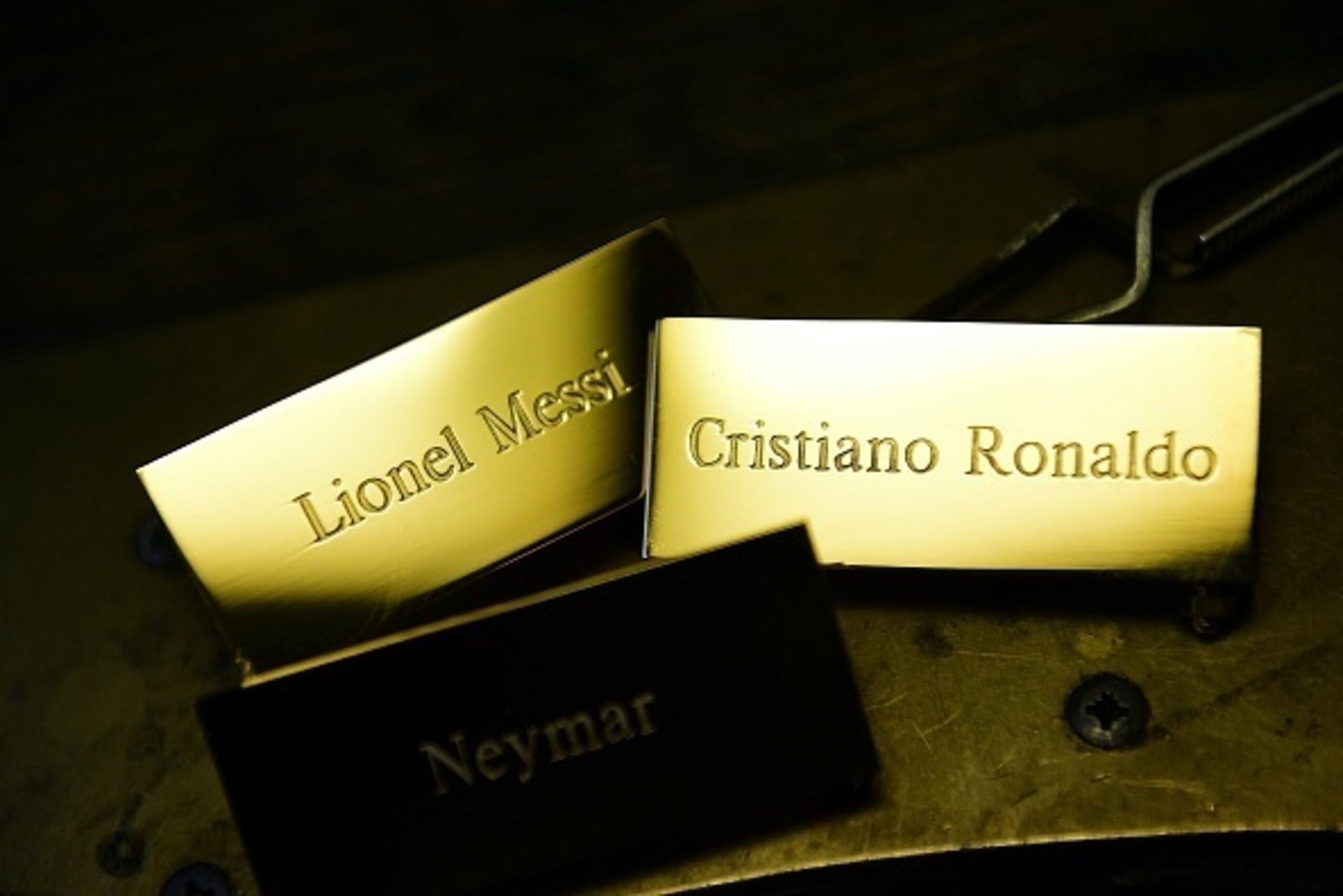 A picture taken on December 15, 2015 shows three plaques reading, 'Cristiano Ronaldo', 'Lionel Messi' and 'Neymar' at the Mellerio jewellers in Paris, as part of the crafting of the Ballon d'Or 2015 Fifa award.
Barcelona's Argentinian forward Lionel Messi