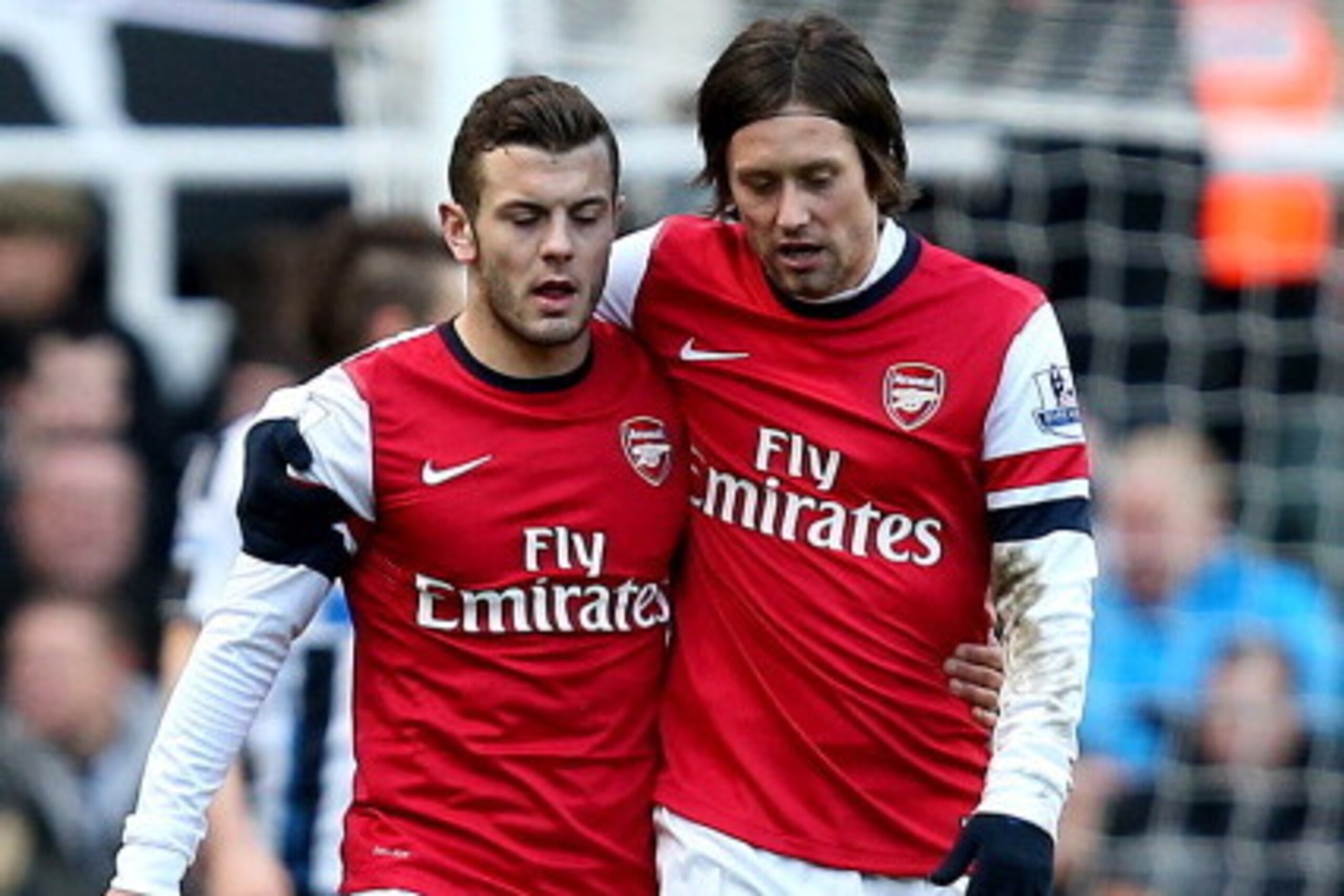 NEWCASTLE UPON TYNE, ENGLAND - DECEMBER 29:  Jack Wilshere of Arsenal and team mate Tomas Rosicky embrace during the Barclays Premier League match between Newcastle United and Arsenal at St James' Park on December 29, 2013 in Newcastle upon Tyne, England.