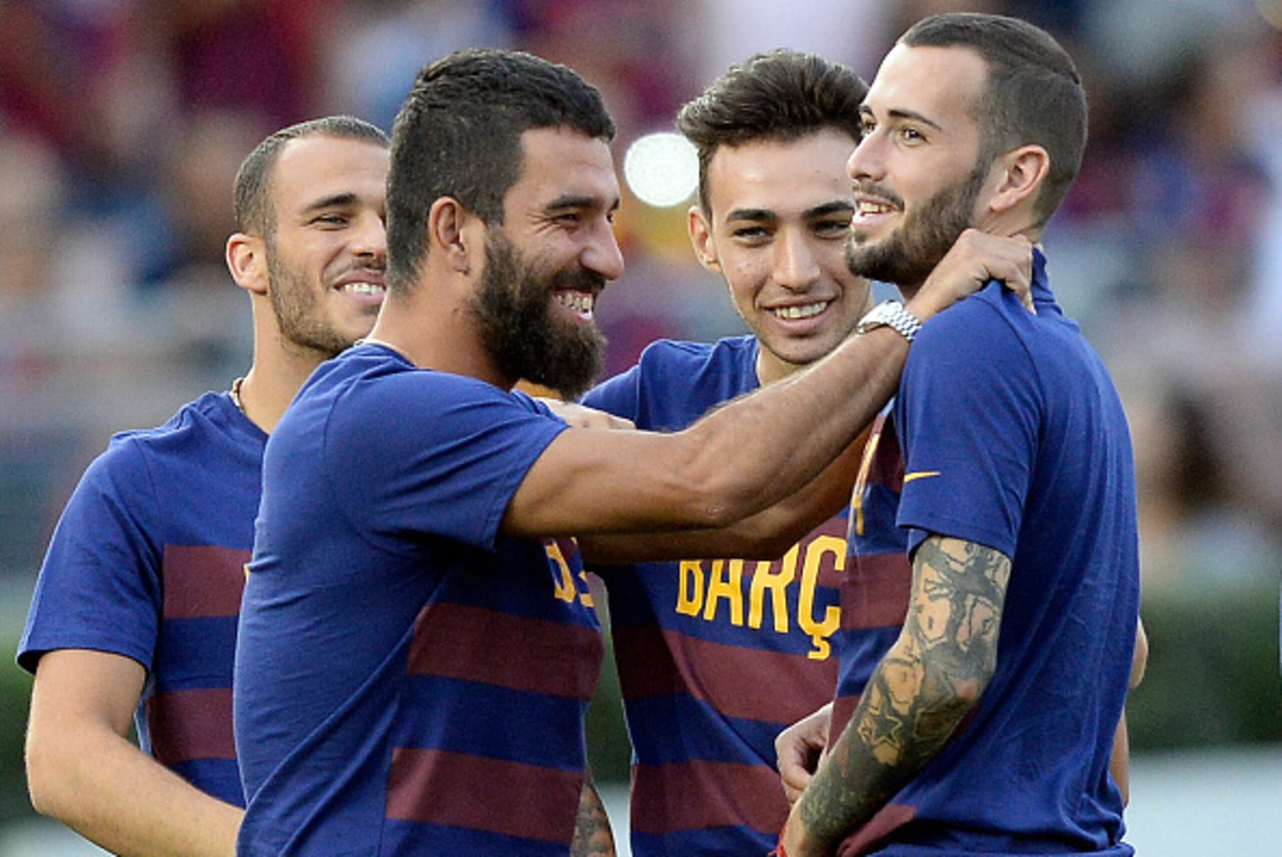 PASADENA, CA - JULY 21: Newly signed midfielder Arda Turan (L) of FC Barcelona hugs teammate Aleix Vidal (R) as Munir El Haddadi #17 and Sandro Ramirez #19 look on during team warm up prior to start of their friendly soccer match against Los Angeles Galax