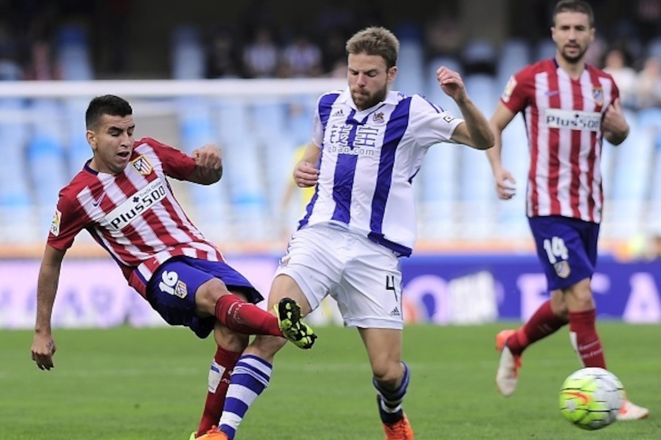 Atletico Madrid's Argentinian midfielder Angel Correa (L) vies with Real Sociedad's midfielder Asier Illarramendi (C) during the Spanish league football match Real Sociedad de Futbol vs Club Atletico de Madrid at the Anoeta stadium in San Sebastian on Oct
