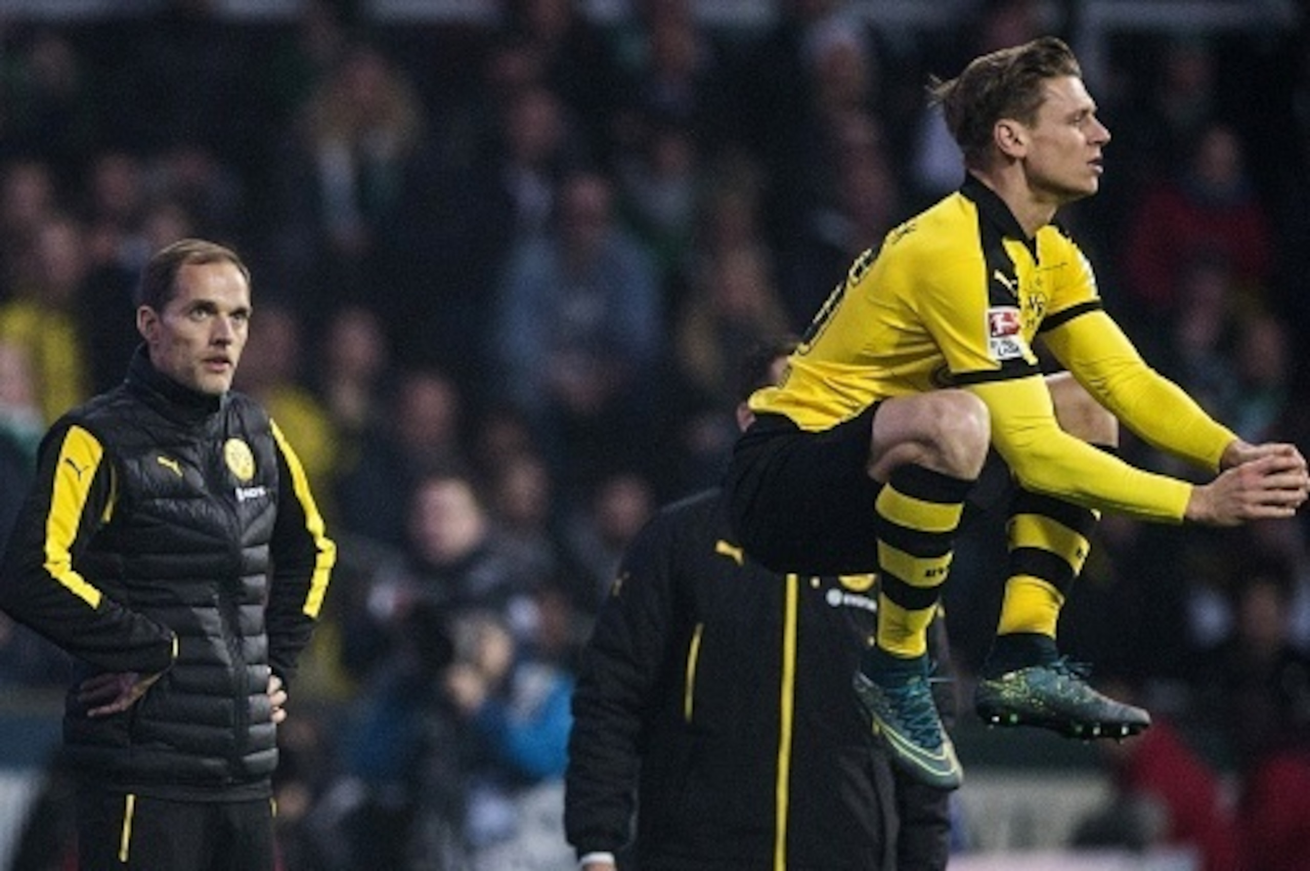 Dortmund's head coach Thomas Tuchel (L) looks on as Dortmund's Polish defender Lukasz Piszczek jumps before entering the pitch during the German first division Bundesliga football match Werder Bremen vs Borussia Dortmund in Bremen, northern Germany, on Oc