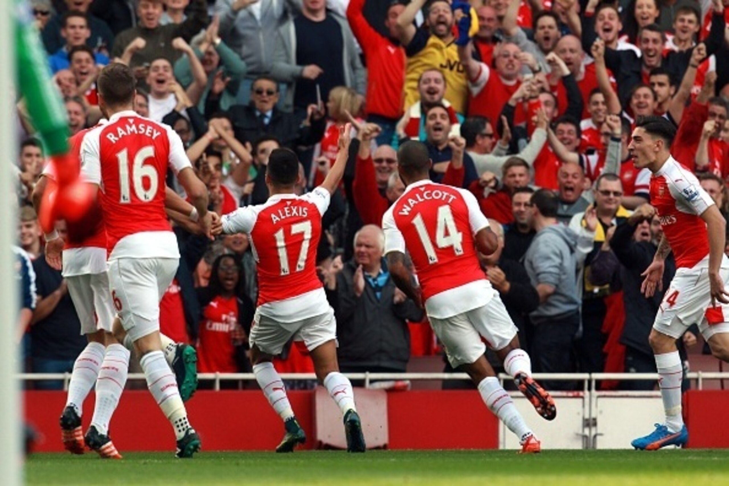 Arsenal's Chilean striker Alexis Sanchez (2L) celebrates his first goal during the English Premier League football match between Arsenal and Manchester United at the Emirates Stadium in London on October 4, 2015.    AFP PHOTO / IKIMAGES

RESTRICTED TO EDI