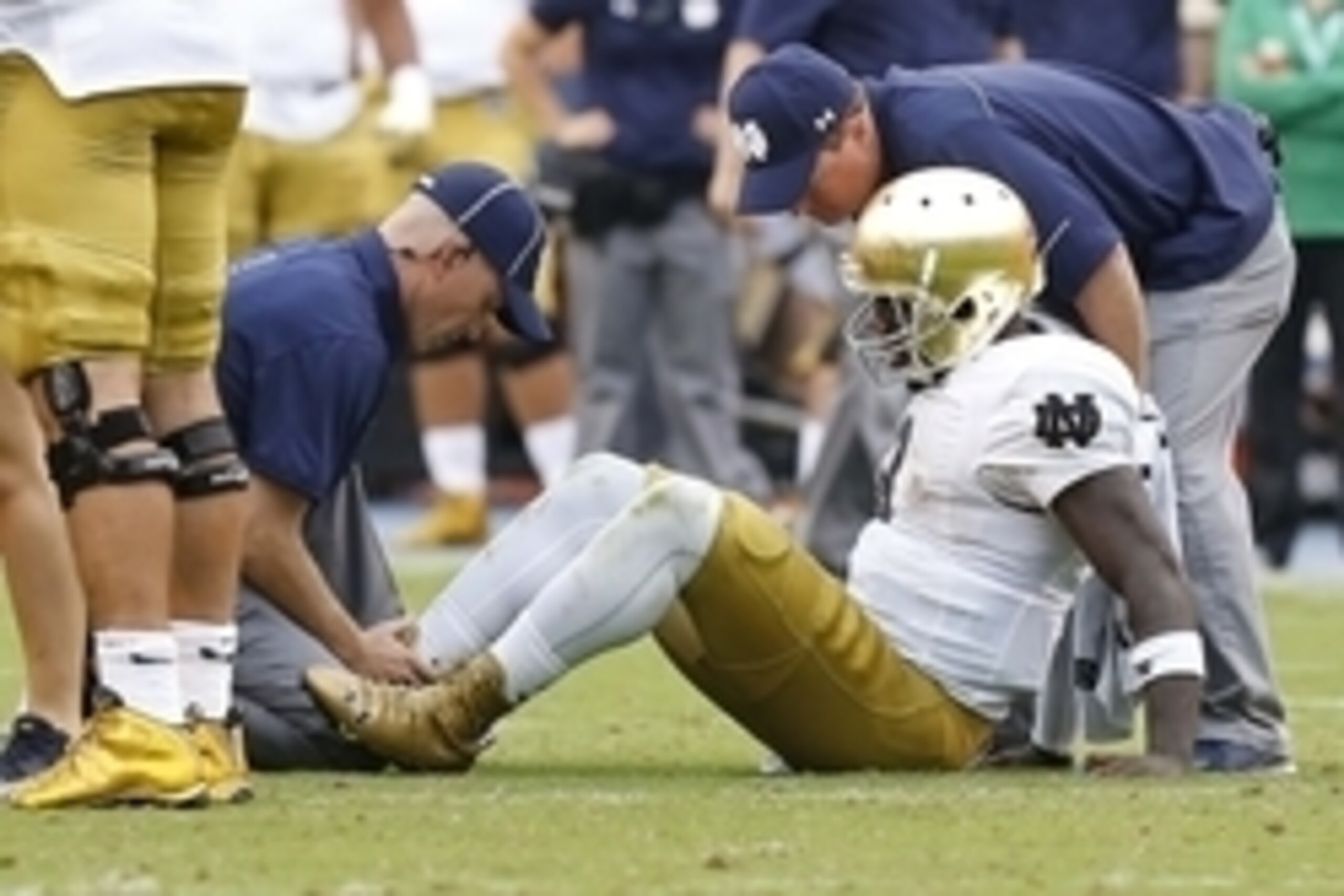 Sep 12, 2015; Charlottesville, VA, USA; Notre Dame Fighting Irish quarterback Malik Zaire (8) is examined by team trainers after injuring his right ankle against the Virginia Cavaliers in the third quarter at Scott Stadium. The Fighting Irish won 34-27. M