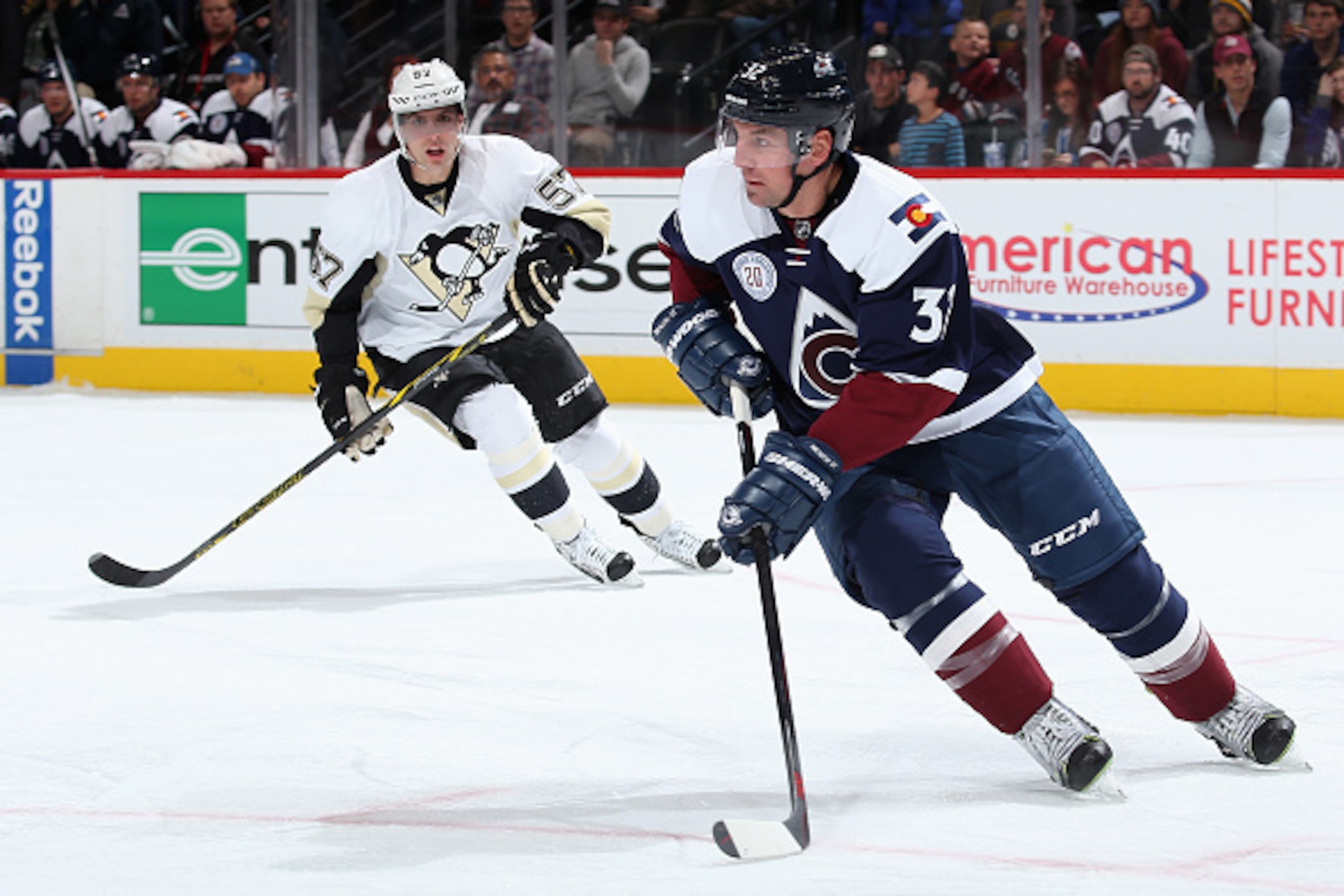 DENVER, CO - DECEMBER 09:  Francois Beauchemin #32 of the Colorado Avalanche controls the puck against David Perron #57 of the Pittsburgh Penguins at Pepsi Center on December 9, 2015 in Denver, Colorado. The Penguins defeated the Avalanche 4-2.  (Photo by
