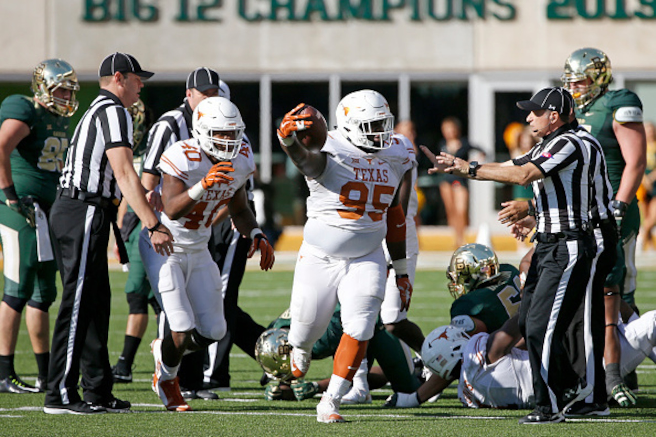 WACO, TX - DECEMBER 5: Poona Ford #95 of theTexas Longhorns celebrates with teammate Naashon Hughes #40 after recovering a fumble against Johnny Jefferson #5 of the Baylor Bears in the fourth quarter at McLane Stadium on December 5, 2015 in Waco, Texas. (