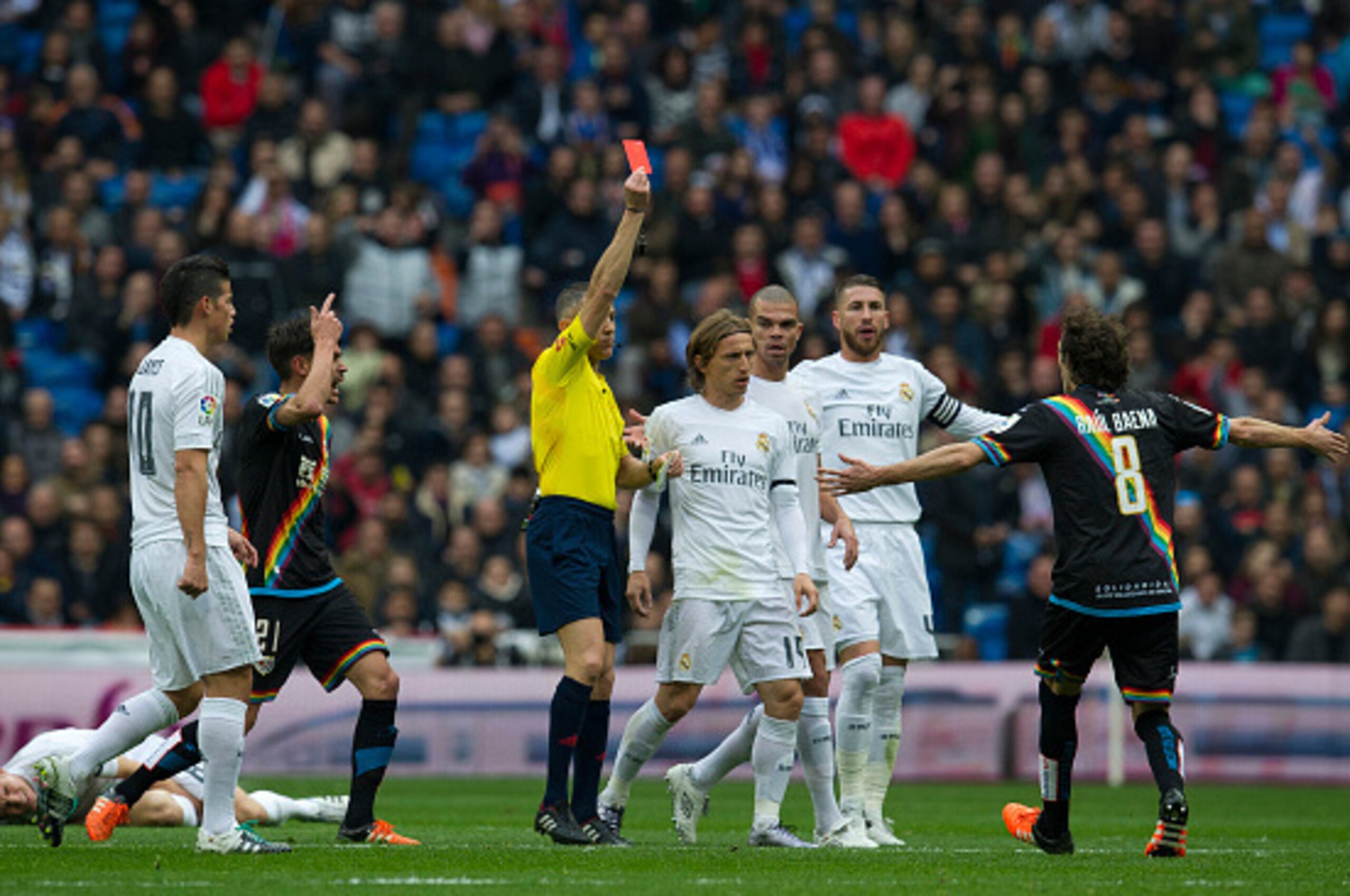 The referee shows a red card to Rayo Vallecano's midfielder Jose Raul Baena (R) during the Spanish league football match Real Madrid CF vs Rayo Vallecano de Madrid at the Santiago Bernabeu stadium in Madrid on December 20, 2015. AFP PHOTO / CURTO DE LA TO The referee shows a red card to Rayo Vallecano's midfielder Jose Raul Baena (R) during the Spanish league football match Real Madrid CF vs Rayo Vallecano de Madrid at the Santiago Bernabeu stadium in Madrid on December 20, 2015. AFP PHOTO / CURTO DE LA TO