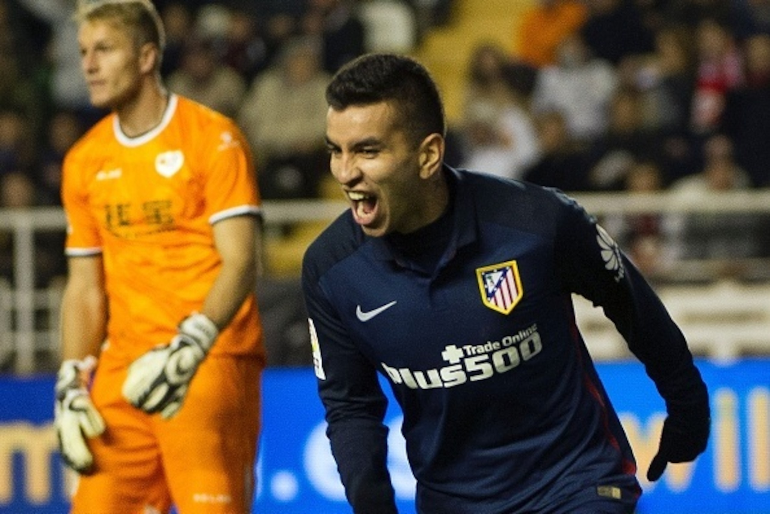 Atletico Madrid's Argentinian midfielder Angel Correa (R) celebrates after scoring during the Spanish league football match Rayo Vallecano de Madrid vs Club Atletico de Madrid at Vallecas stadium in Madrid on December 30, 2015.   AFP PHOTO/ CURTO DE LA TO
