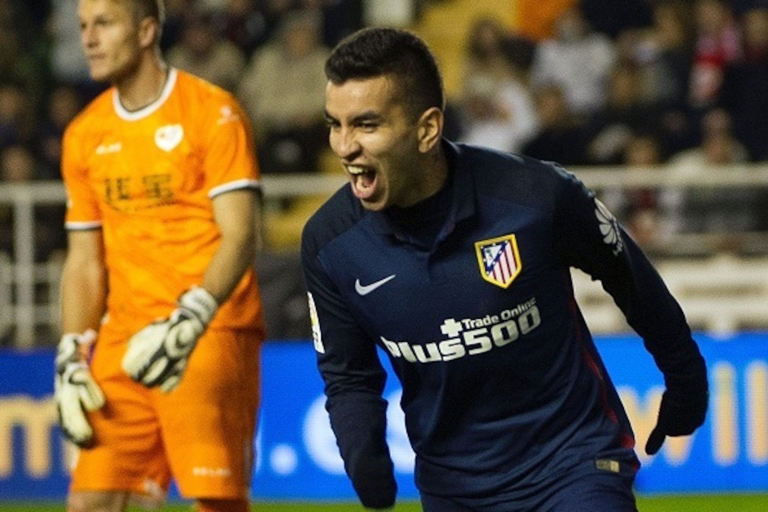 Atletico Madrid's Argentinian midfielder Angel Correa (R) celebrates after scoring during the Spanish league football match Rayo Vallecano de Madrid vs Club Atletico de Madrid at Vallecas stadium in Madrid on December 30, 2015.   AFP PHOTO/ CURTO DE LA TO