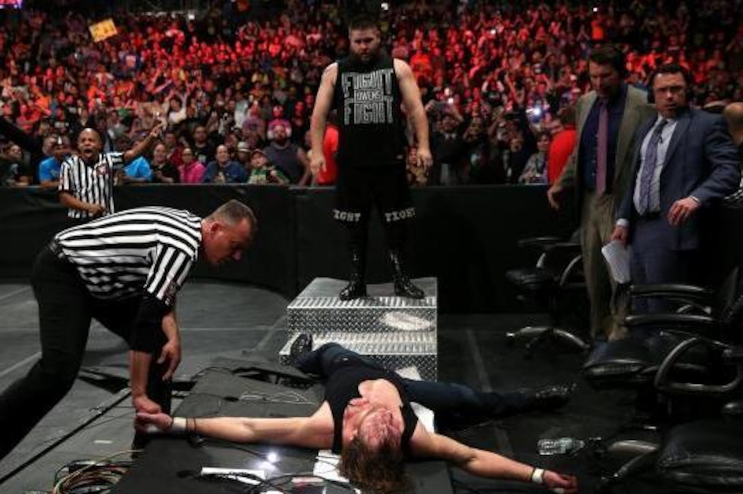 Kevin Owens admires his work after attacking Dean Ambrose.