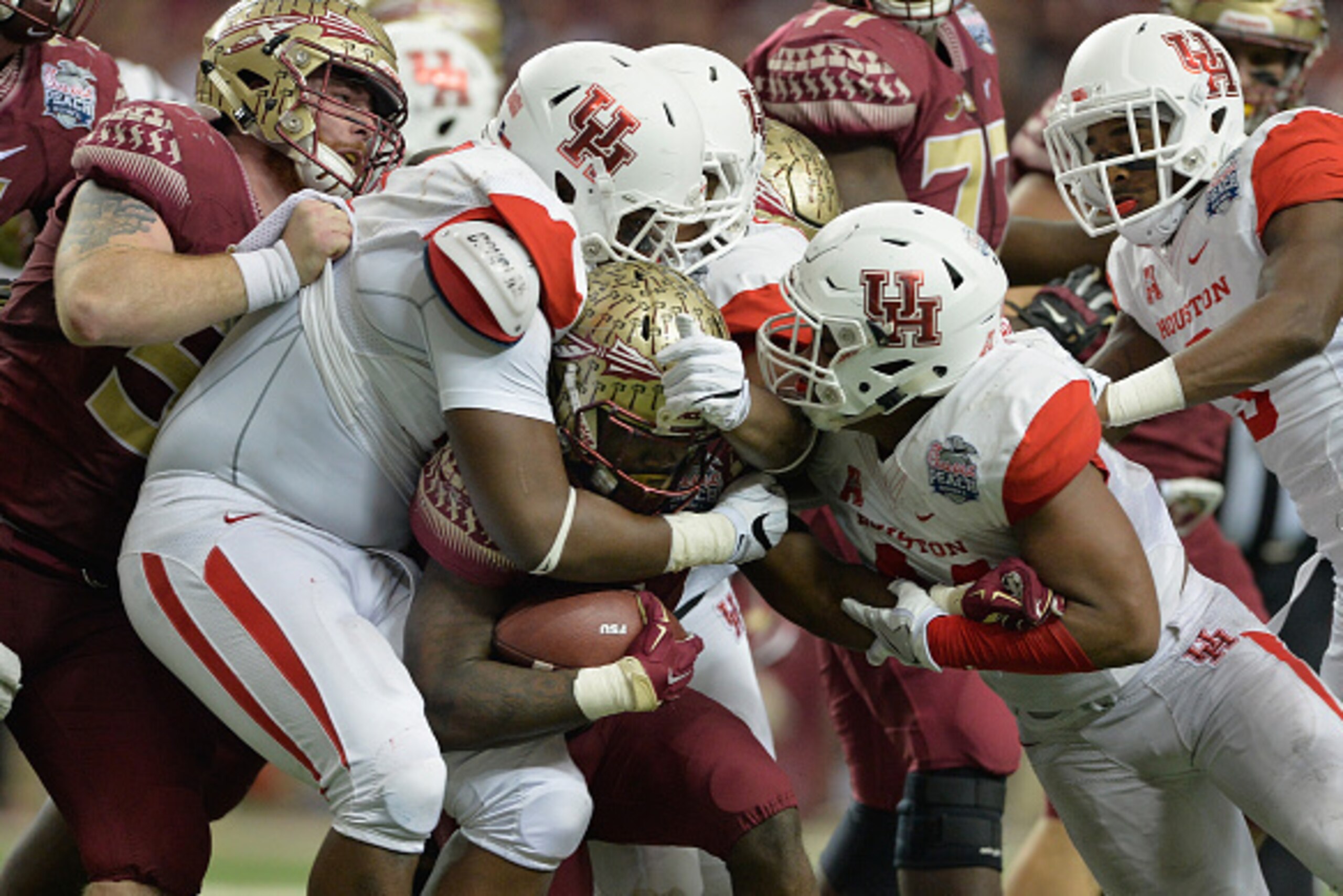 ATLANTA, GA - DECEMBER 31: Elandon Roberts #44, Nick Thurman #91 and Jerard Carter #52 of the Houston Cougars tackle Dalvin Cook #4 of the Florida State Seminoles in the third quarter during the Chick-fil-A Peach Bowl at the Georgia Dome on December 31, 2