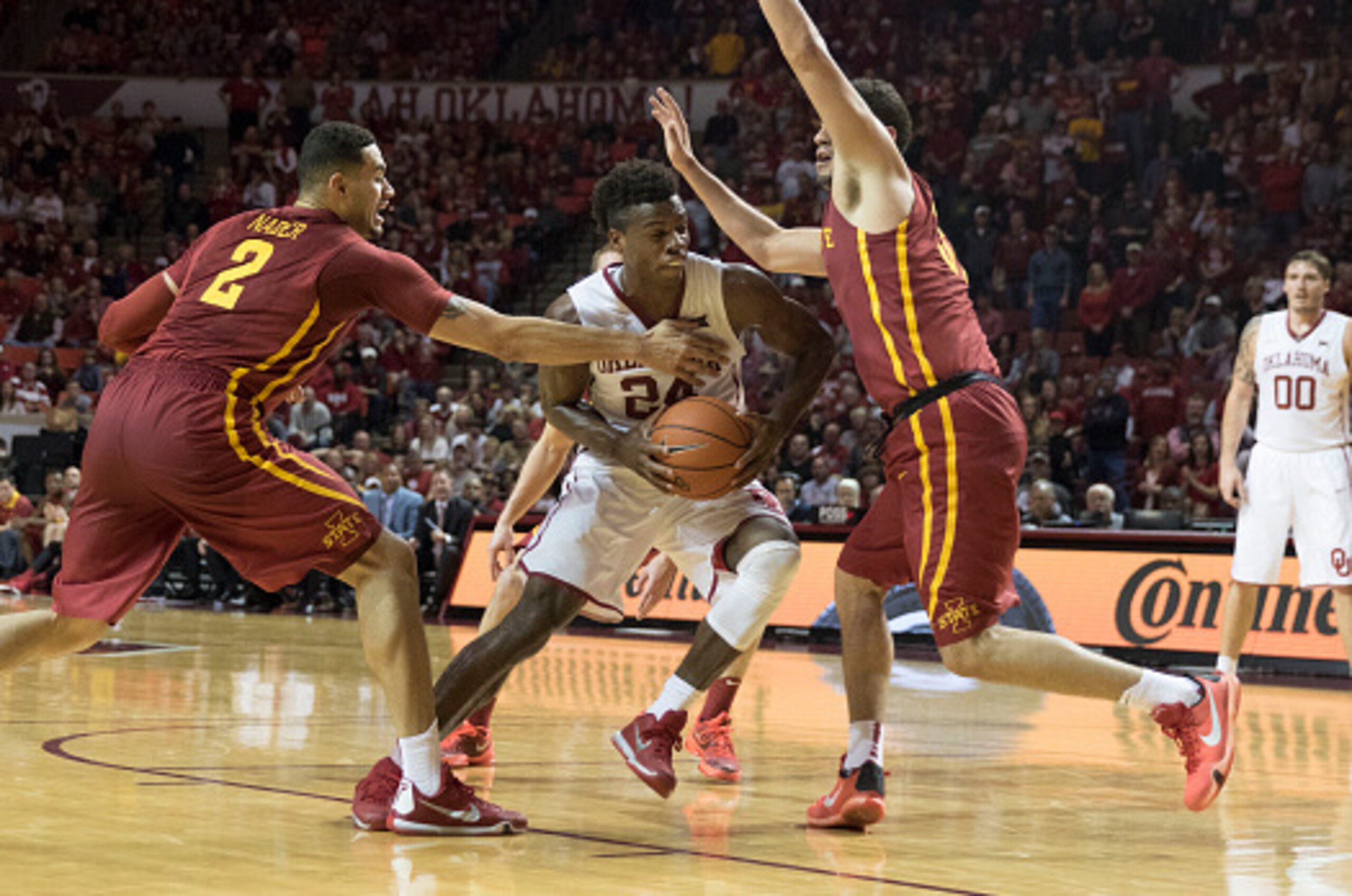NORMAN, OK - JANUARY 2: Buddy Hield #24 of the Oklahoma Sooners drives between Abdel Nader #2 and Georges Niang #31 of the Iowa State Cyclones during the second half of a NCAA college basketball game at the Lloyd Noble Center on January 2, 2016 in Norman,