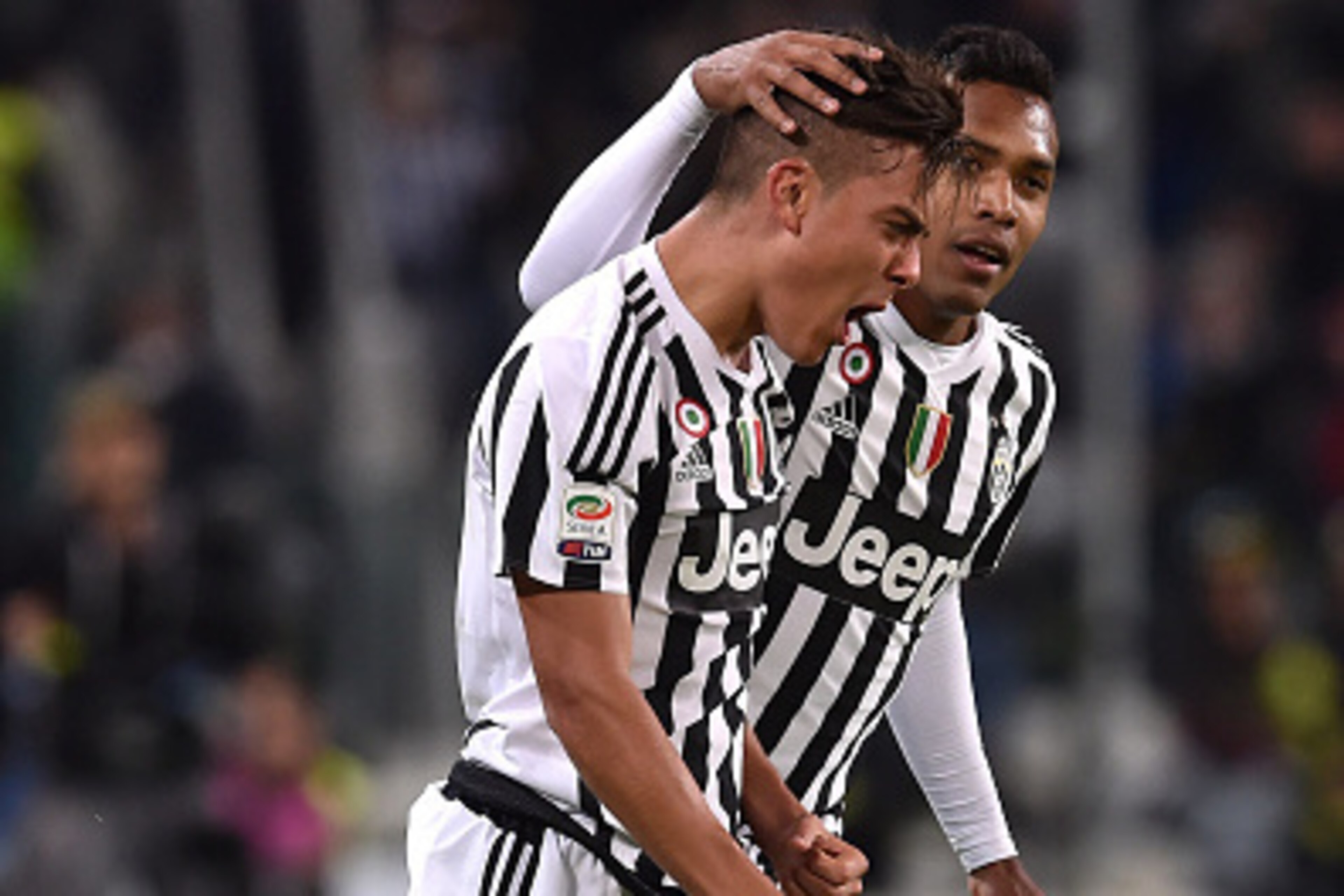 TURIN, ITALY - NOVEMBER 21:  Paulo Dybala (L) of Juventus FC celebrates after scoring the opening goal with team mate Alex Sandro during the Serie A match between Juventus FC and AC Milan at Juventus Arena on November 21, 2015 in Turin, Italy.  (Photo by 