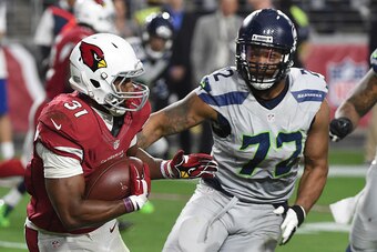 GLENDALE, AZ - JANUARY 03:  Running back David Johnson #31 of the Arizona Cardinals carries the football in front of defensive end Michael Bennett #72 of the Seattle Seahawks at University of Phoenix Stadium on January 3, 2016 in Glendale, Arizona.  The S