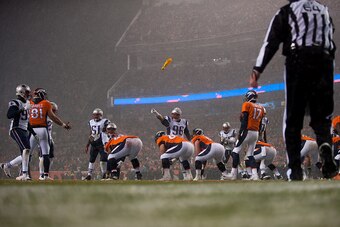 DENVER, CO - NOVEMBER 29: A flag is thrown and defensive tackle Sealver Siliga #96 of the New England Patriots points at tight end Owen Daniels #81 of the Denver Broncos after a false start by the Denver Broncos as Brock Osweiler #17 runs the offense duri