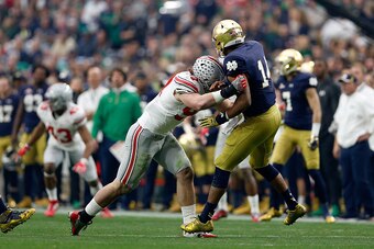 GLENDALE, AZ - JANUARY 01:  Defensive lineman Joey Bosa #97 of the Ohio State Buckeyes hits quarterback DeShone Kizer #14 of the Notre Dame Fighting Irish during the first quarter of the BattleFrog Fiesta Bowl at University of Phoenix Stadium on January 1