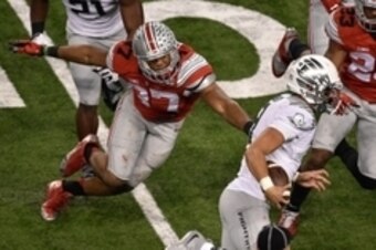 Jan 12, 2015; Arlington, TX, USA; Ohio State Buckeyes linebacker Joshua Perry (37) tries to tackle Oregon Ducks quarterback Marcus Mariota (8) during the game at AT&T Stadium. The Buckeyes defeated the Ducks 42-20. Mandatory Credit: Jerome Miron-USA TODAY